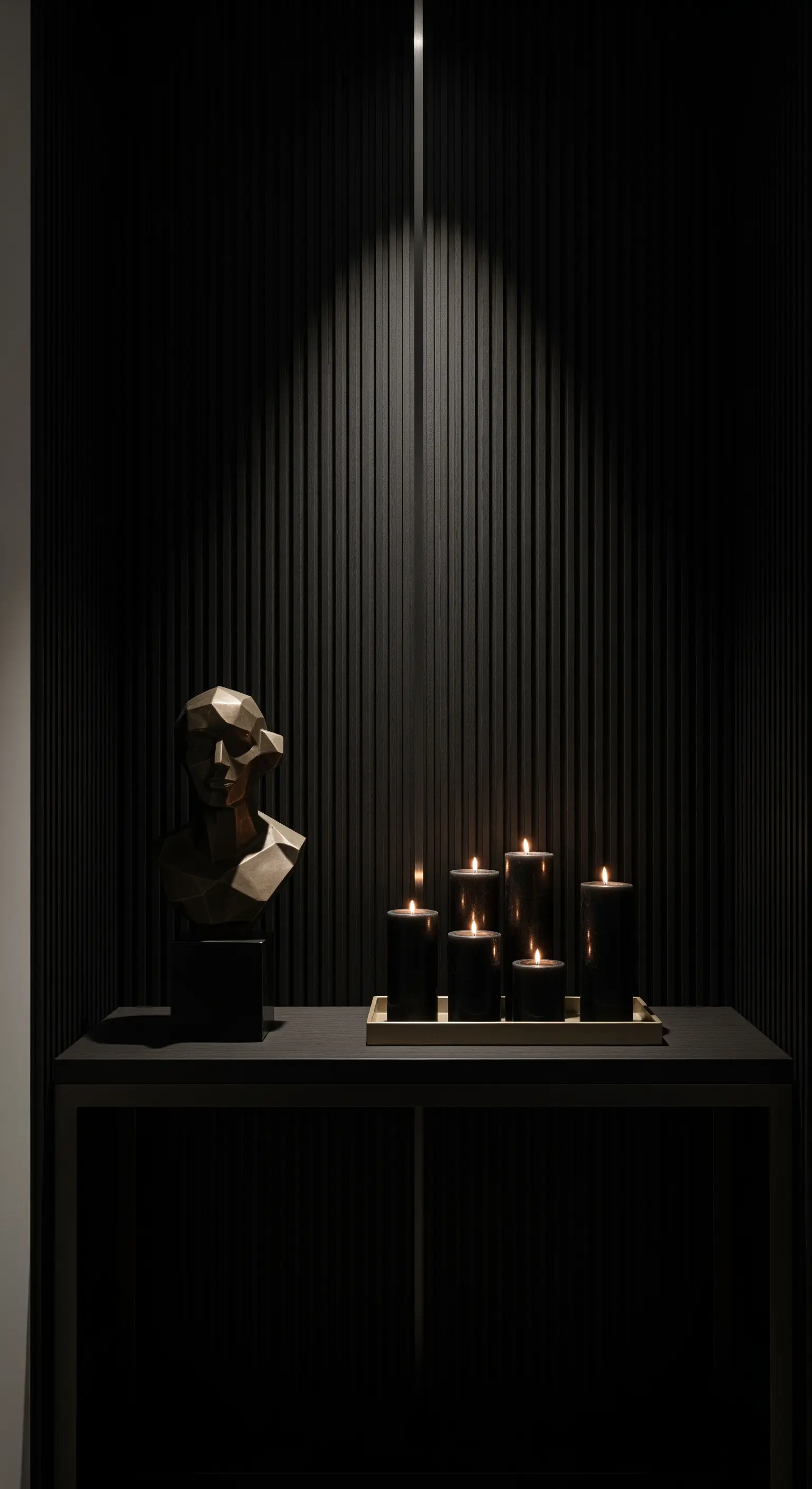 Eingangsbereich mit Konsolentisch, mattschwarzen Kerzen, geometrischer Skulptur und Spotlight