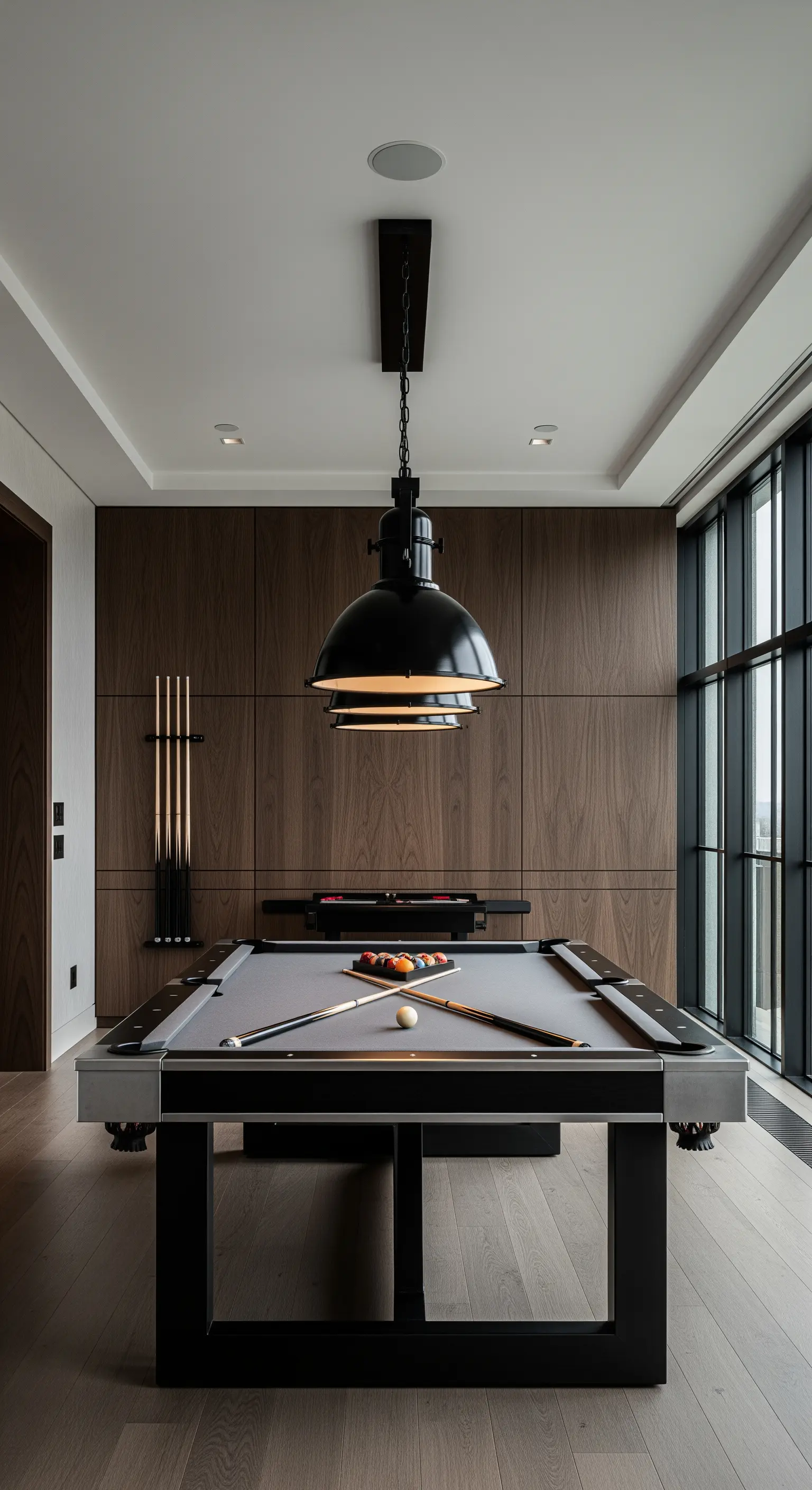 Billardzimmer mit Holzwand, dunklem Billardtisch und markanter Pendelleuchte