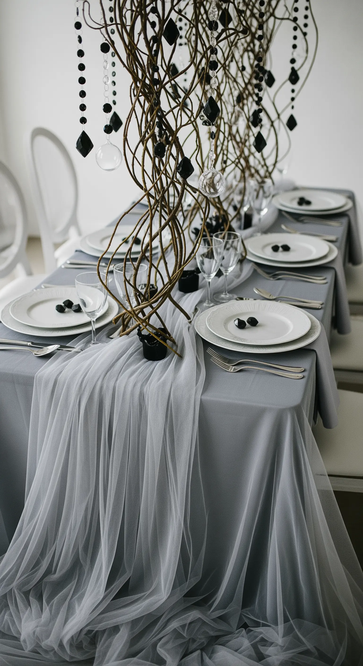 Geisterhafte Halloween Tischdeko mit grauem Tüll, Ästen und schwarzen Perlen