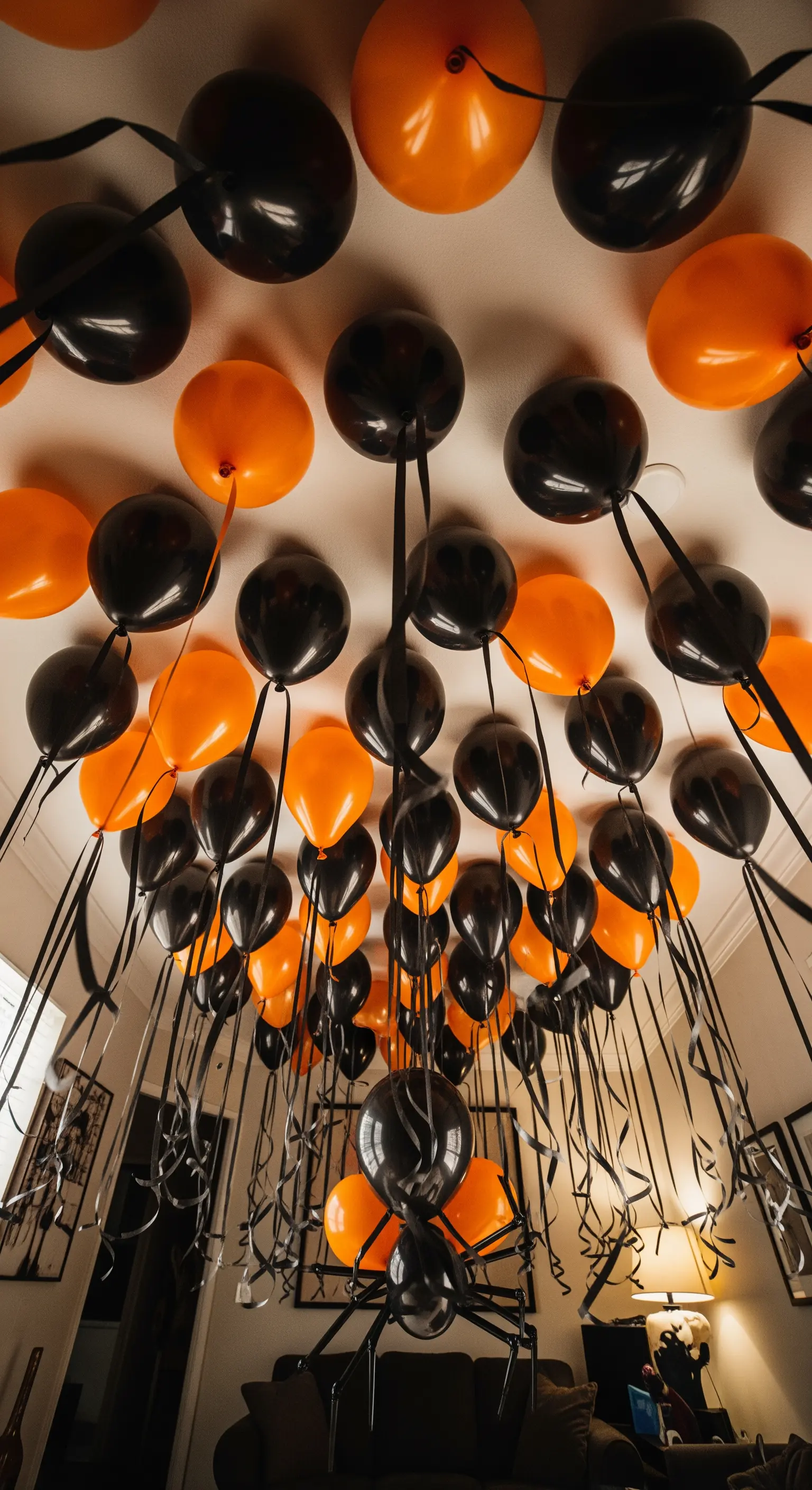 Halloween Ballon-Deko mit schwarzen und orangen Ballons, großer Spinne an der Decke.