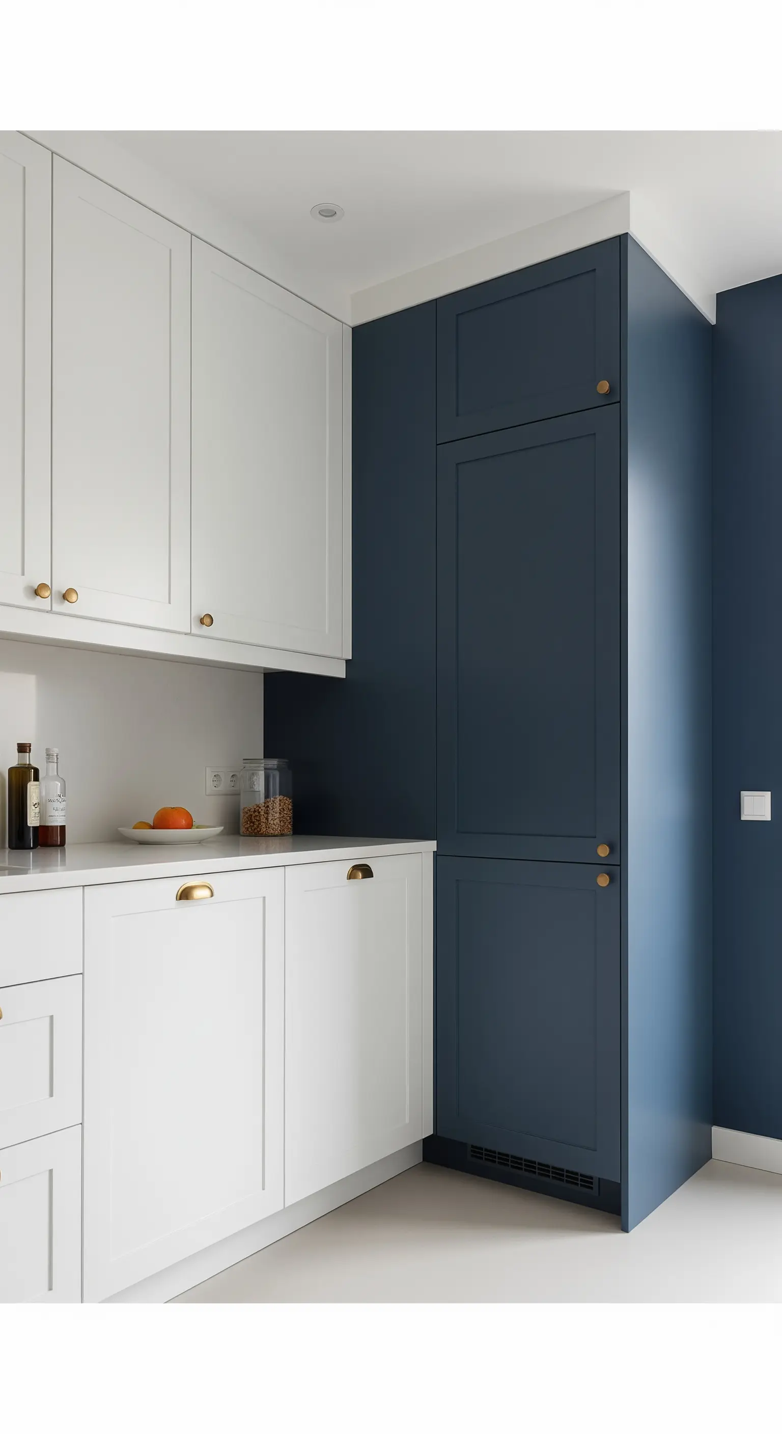 Küche mit weißen Unterschränken und einem deckenhohen, dunkelblauen Schrank als farblicher Akzent.