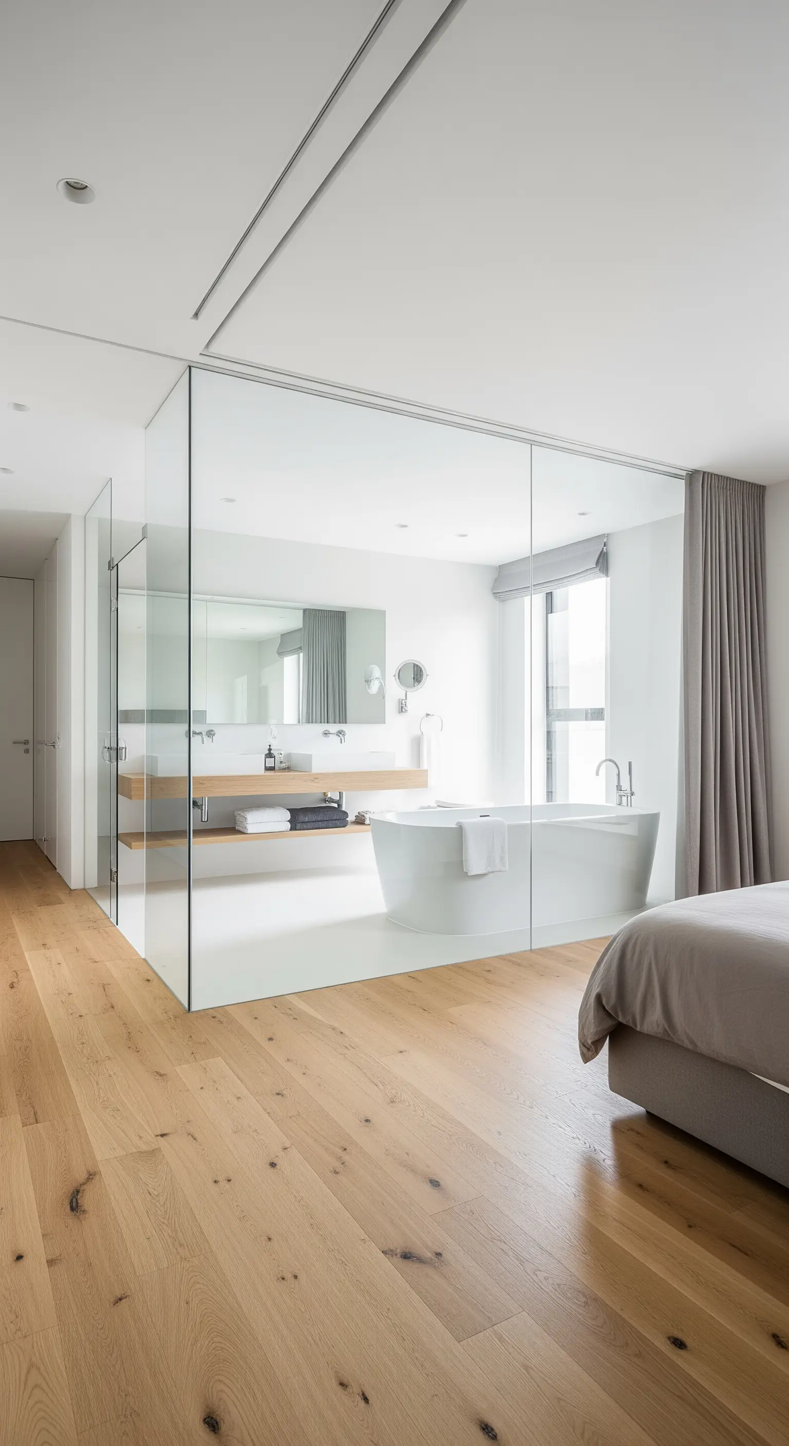 Offenes Badezimmer, durch Glaswände vom Schlafzimmer getrennt.