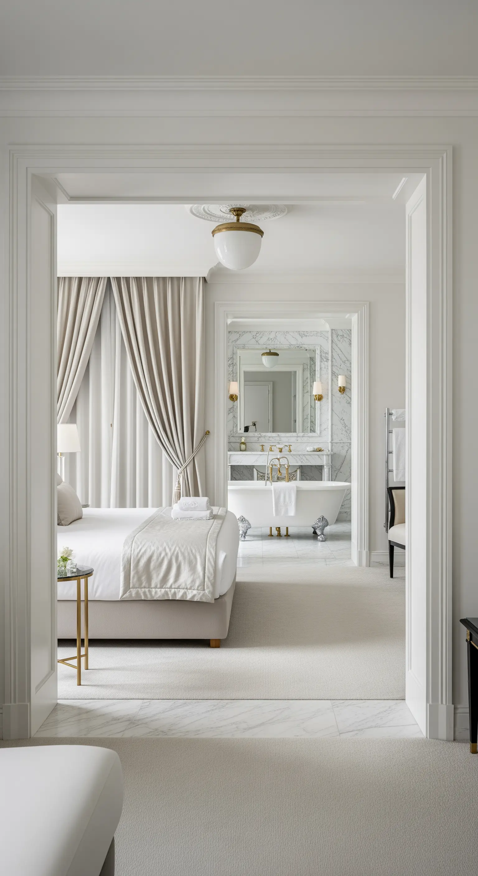 Blick von einem eleganten Schlafzimmer in ein offenes Badezimmer mit freistehender Wanne