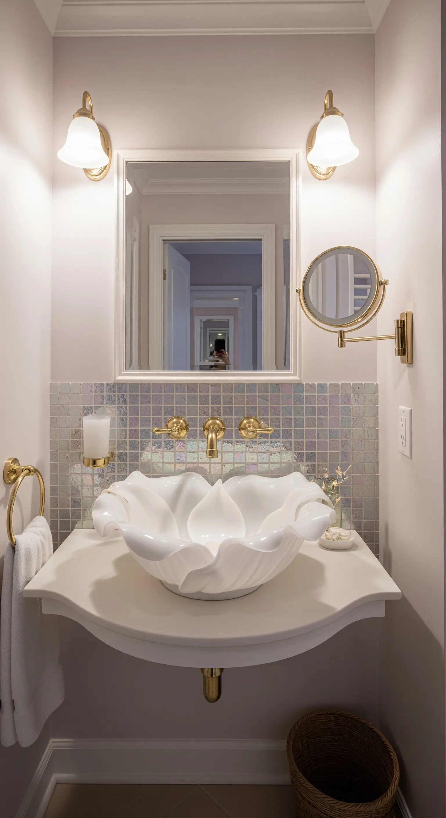 Weißes Keramikwaschbecken in Form einer Blüte vor einer schillernden Mosaikwand.