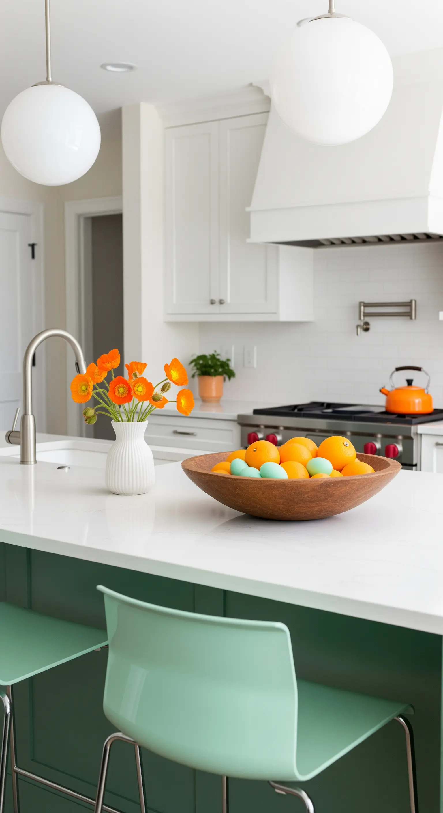 Kücheninsel mit grünen Hockern, Orangen, Ostereiern und orangen Blumen.
