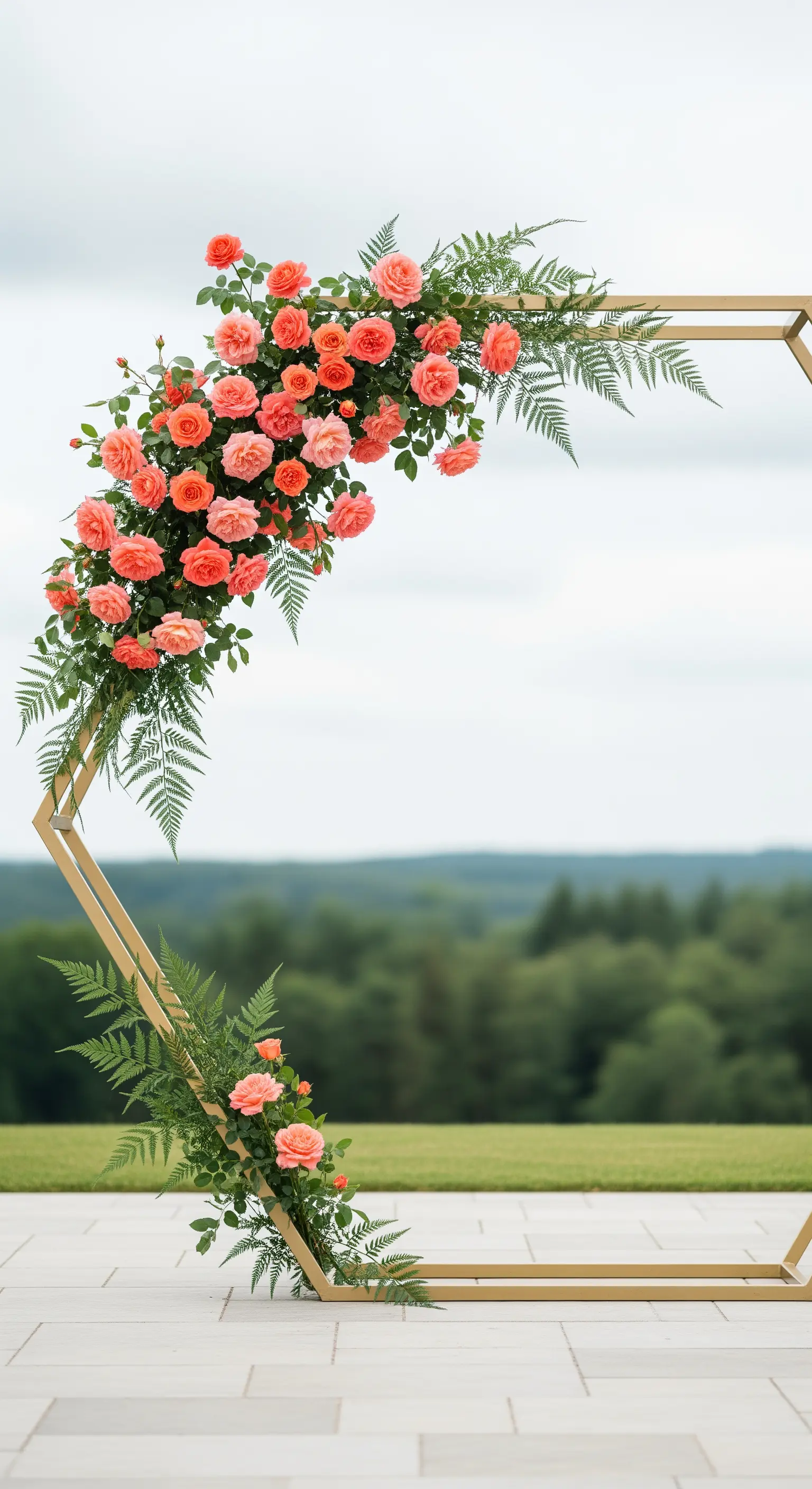 Geometrischer goldener Bogen, verziert mit korallenfarbenen Rosen und frischen Farnen, vor einer Landschaft.