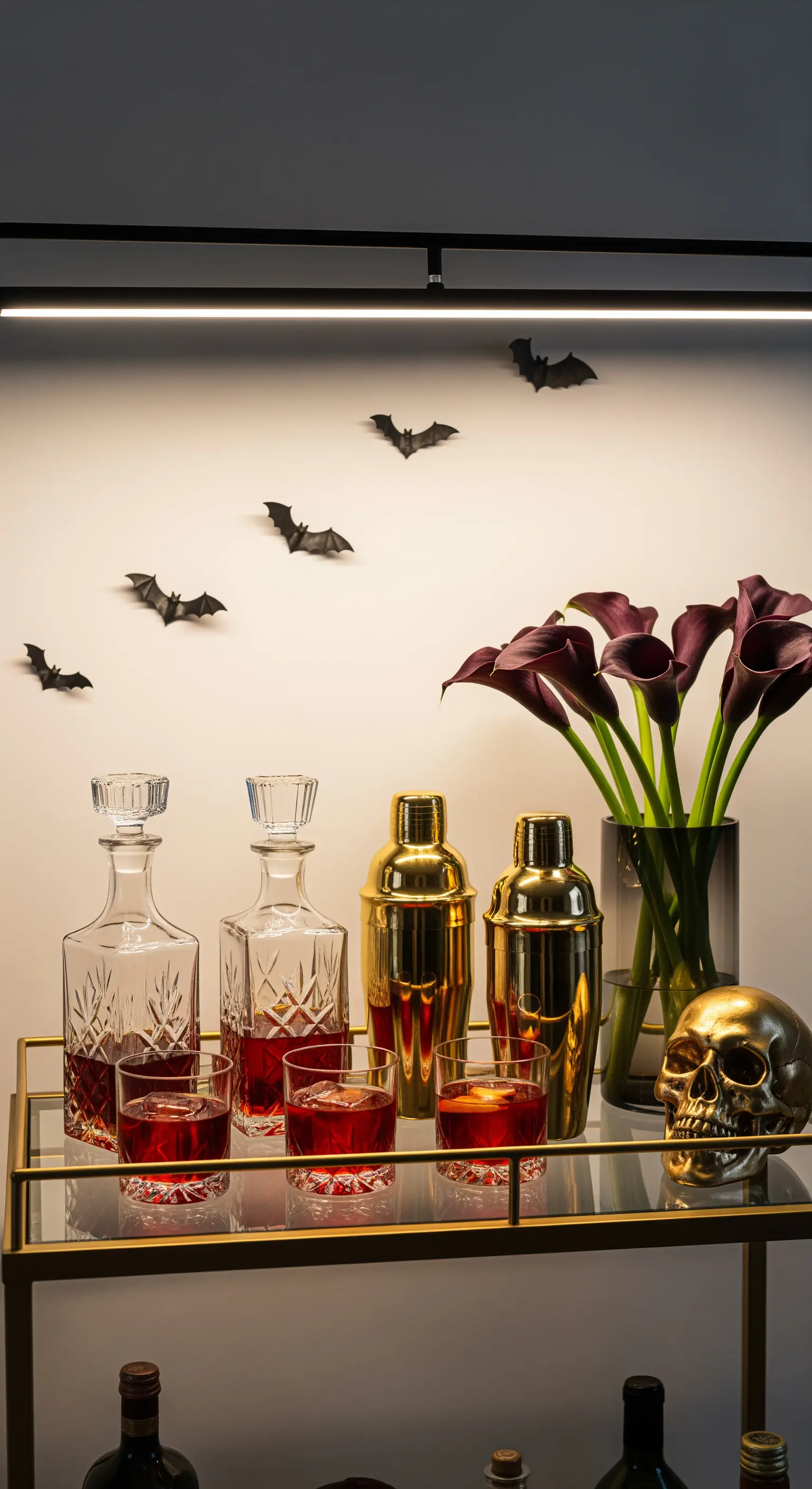 Barwagen mit goldenen Cocktail-Shakern, Karaffen, Totenkopf, Calla-Lilien und Fledermaus-Wanddeko.