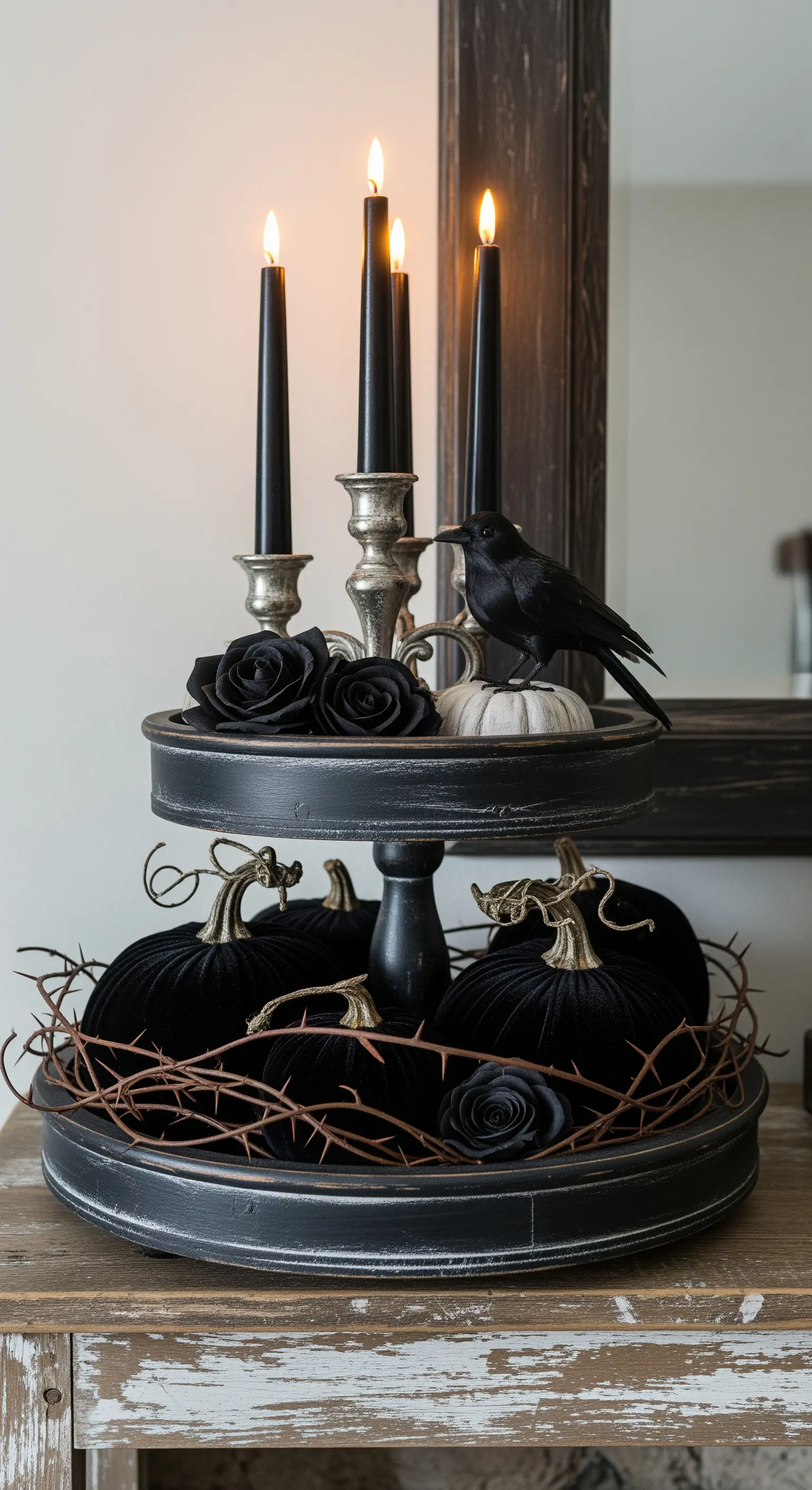 Düstere Gothic-Halloween-Etagere mit schwarzen Kerzen, Raben und Samtkürbissen.