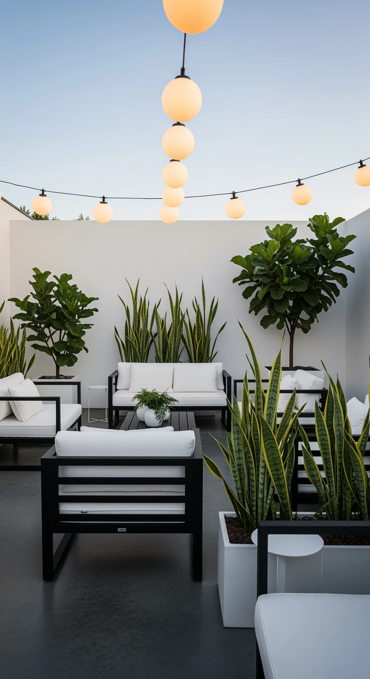 Moderne, minimalistische Terrasse mit schwarz-weißen Möbeln und kugelförmigen Lichterketten.
