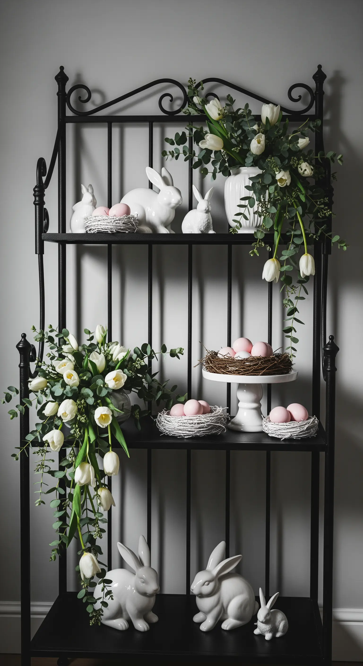 Schwarzes Metallregal mit weißen Tulpen, Eukalyptus und Keramikhasen