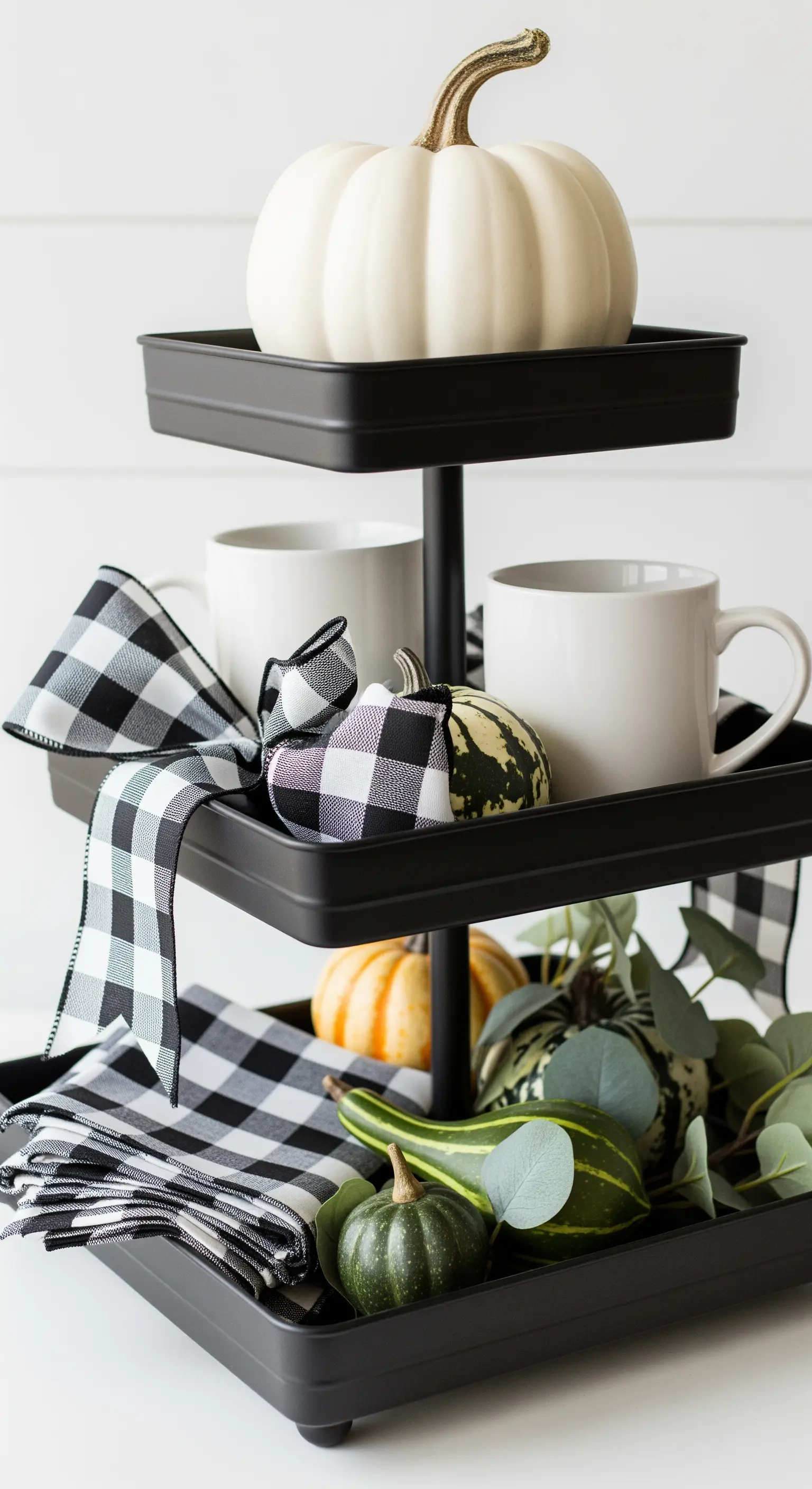 Schwarze quadratische Etagere mit schwarz-weißem Karoband und weißen Kürbissen