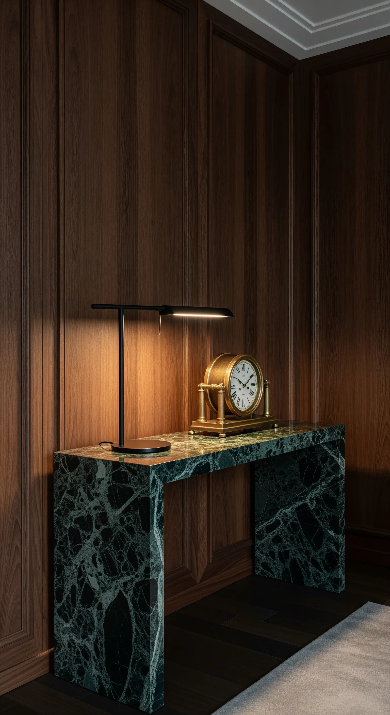 Grüne Marmorkonsole in einem holzvertäfelten Arbeitszimmer mit Messinglampe und Uhr
