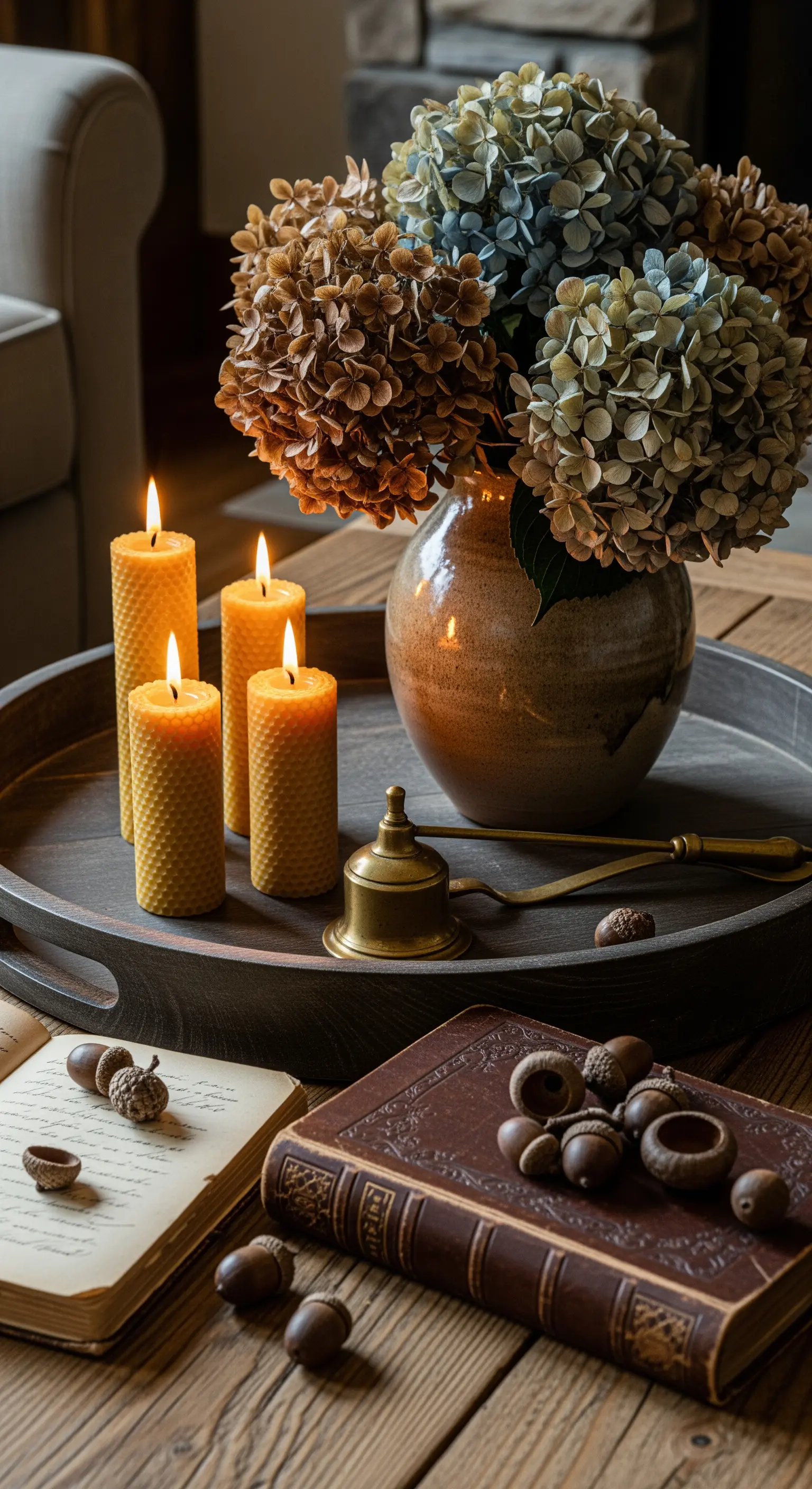 Kaffeetisch mit getrockneten Hortensien, Bienenwachskerzen, alten Büchern, Eicheln.