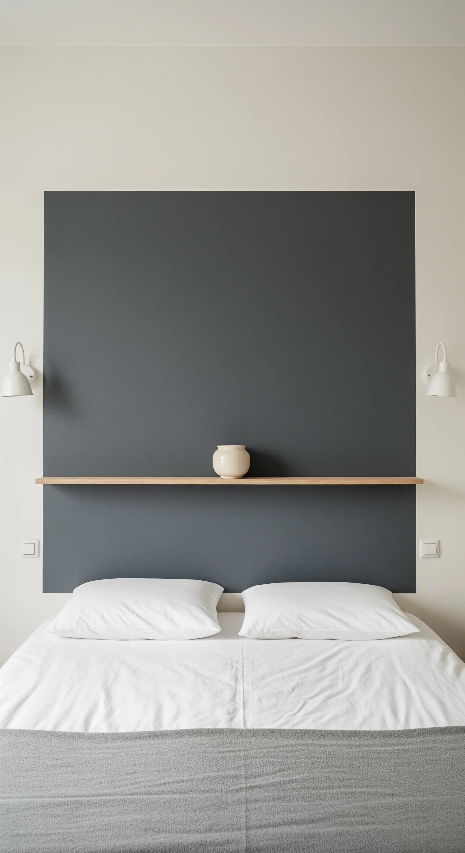 Dunkelgraue Wandfläche als Kopfteil mit integriertem Holzregal über einem Bett.