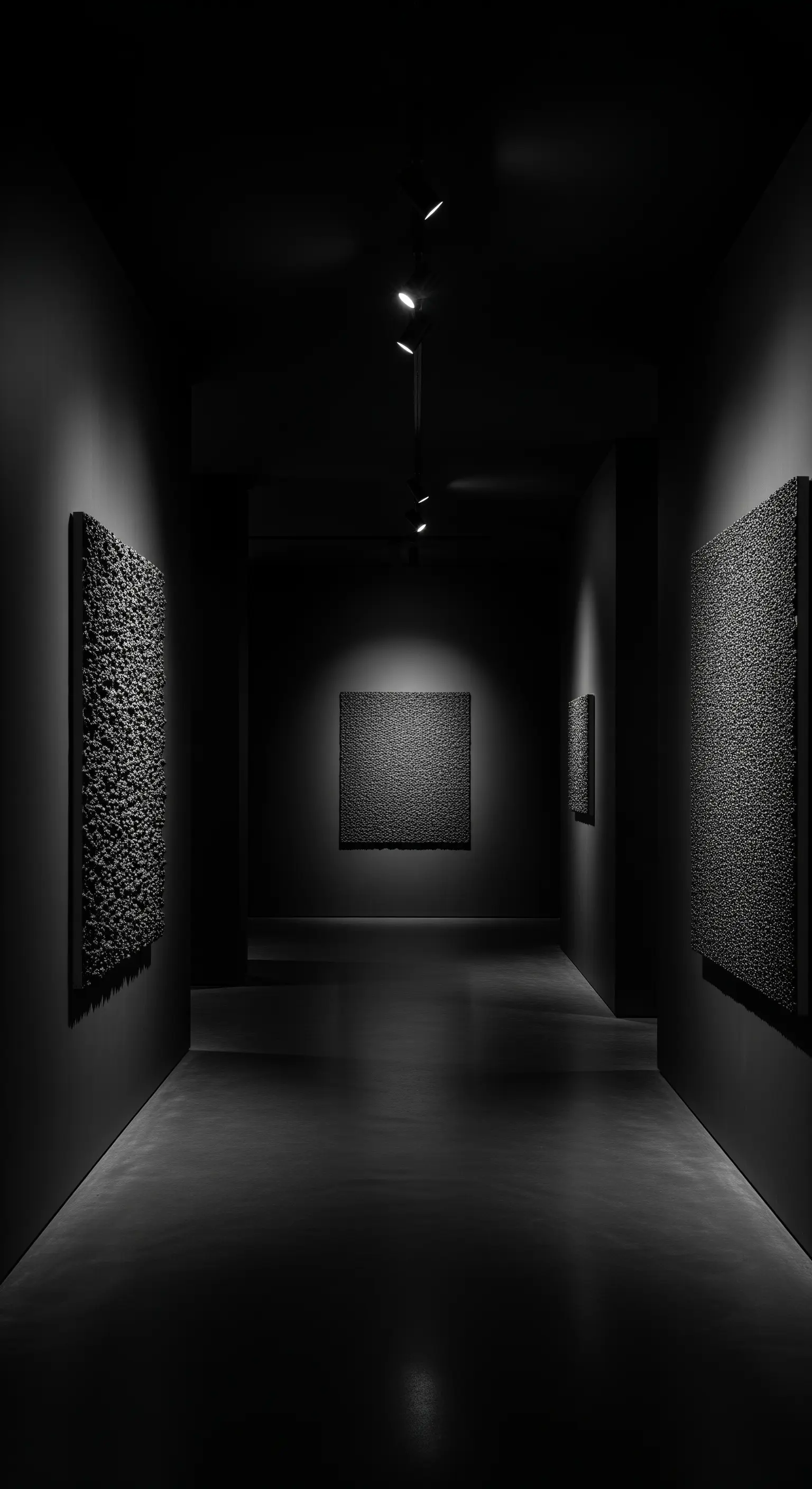 Dunkler Korridor als Kunstgalerie mit monochromen, strukturierten Werken
