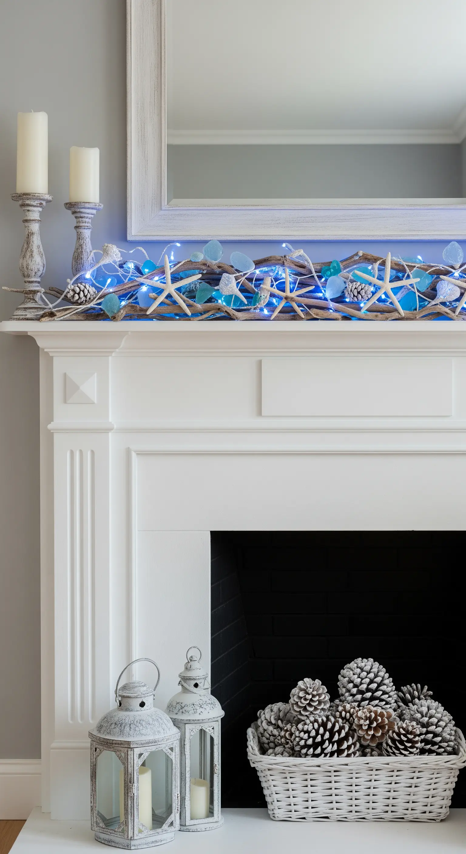 Winterliche Küstendeko am Kamin mit blauen Lichtern, Treibholz und Seesternen.
