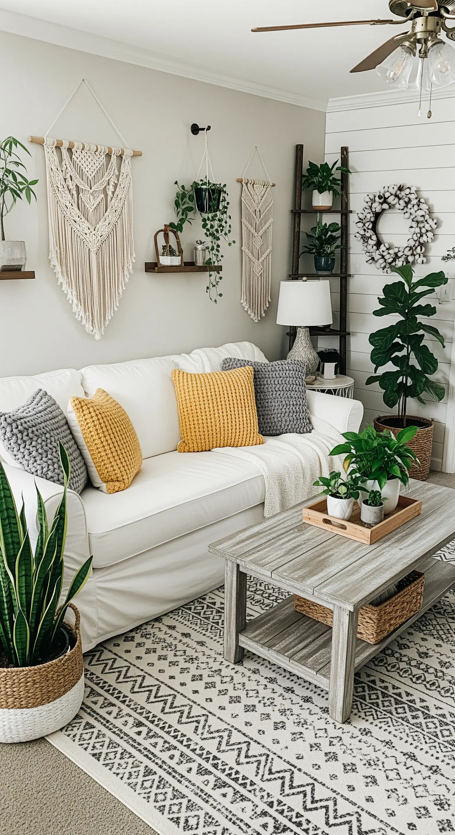 Helles Wohnzimmer mit weißem Sofa, Makramee und Kissen in Senfgelb und Grau.