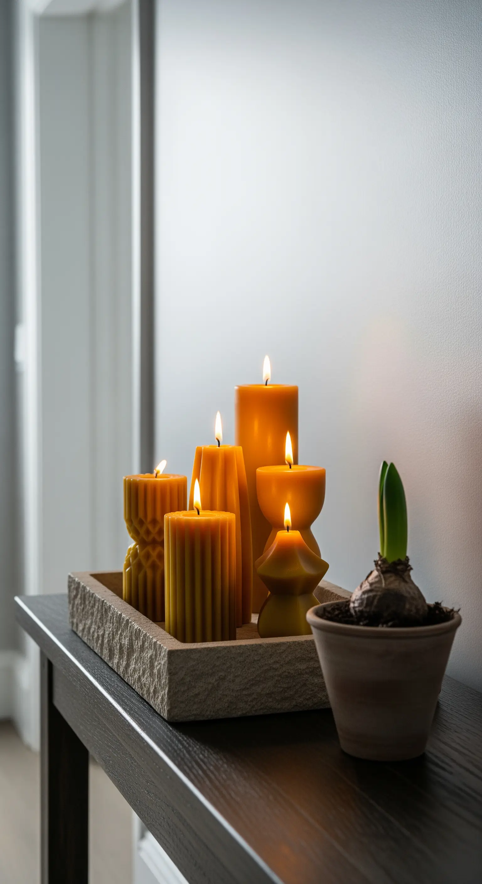Dunkler Konsolentisch mit Bienenwachskerzen auf Steintablett und Hyazinthe