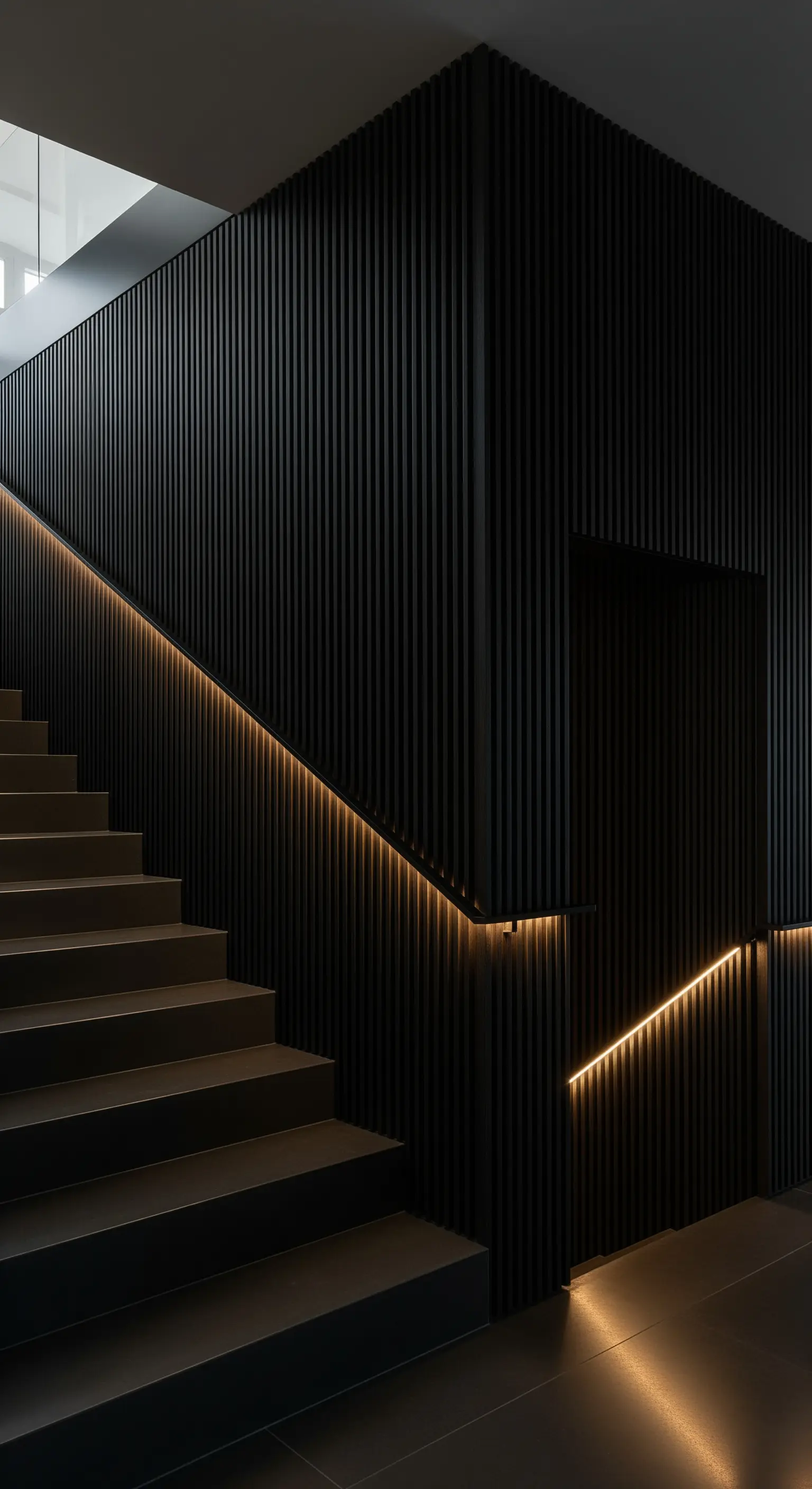 Treppenhaus mit schwarzer Lamellenwand und einem beleuchteten Handlauf.