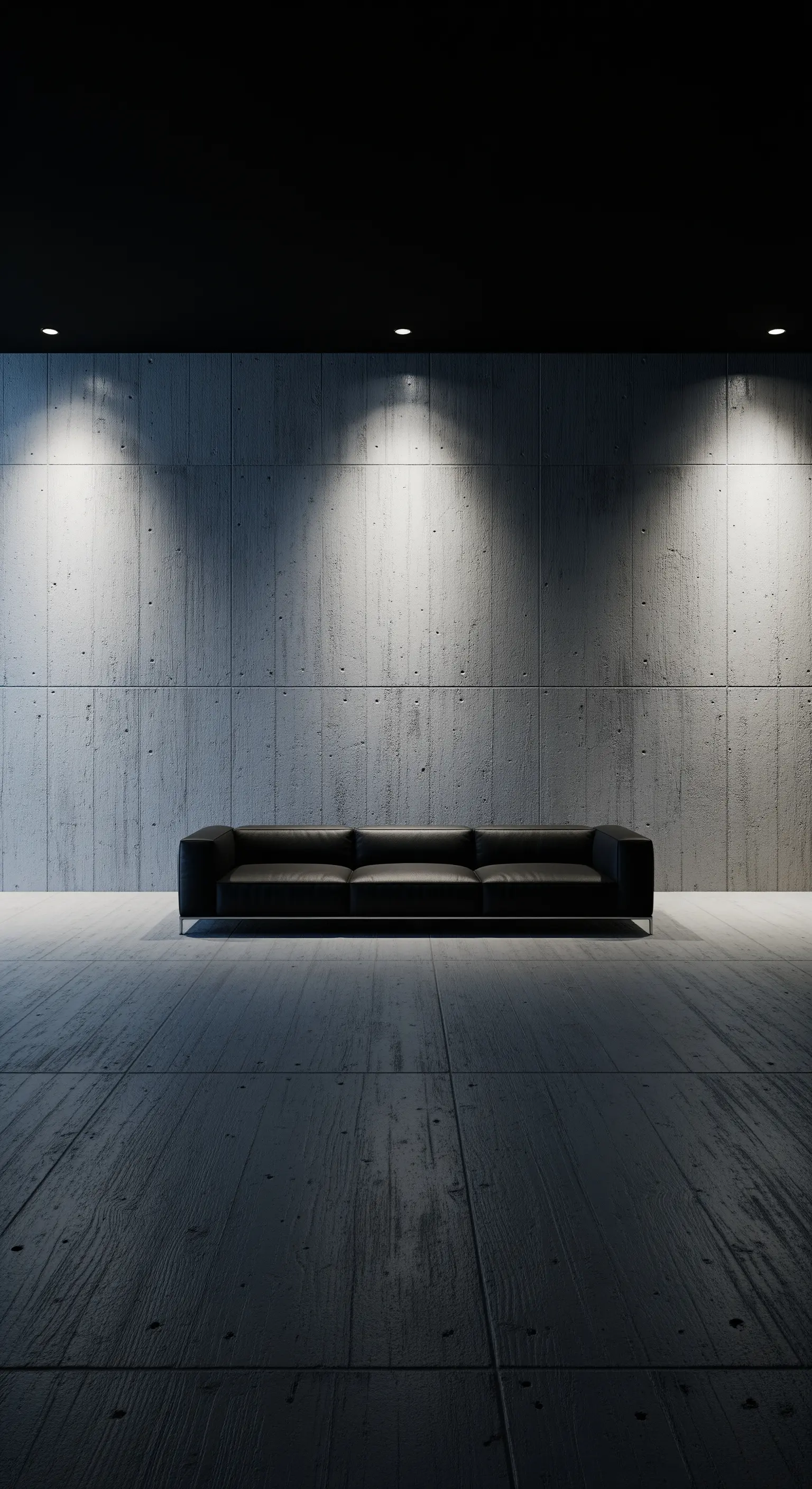 Dramatisch beleuchtete Betonwand hinter einem schwarzen Ledersofa in einem minimalistischen Raum