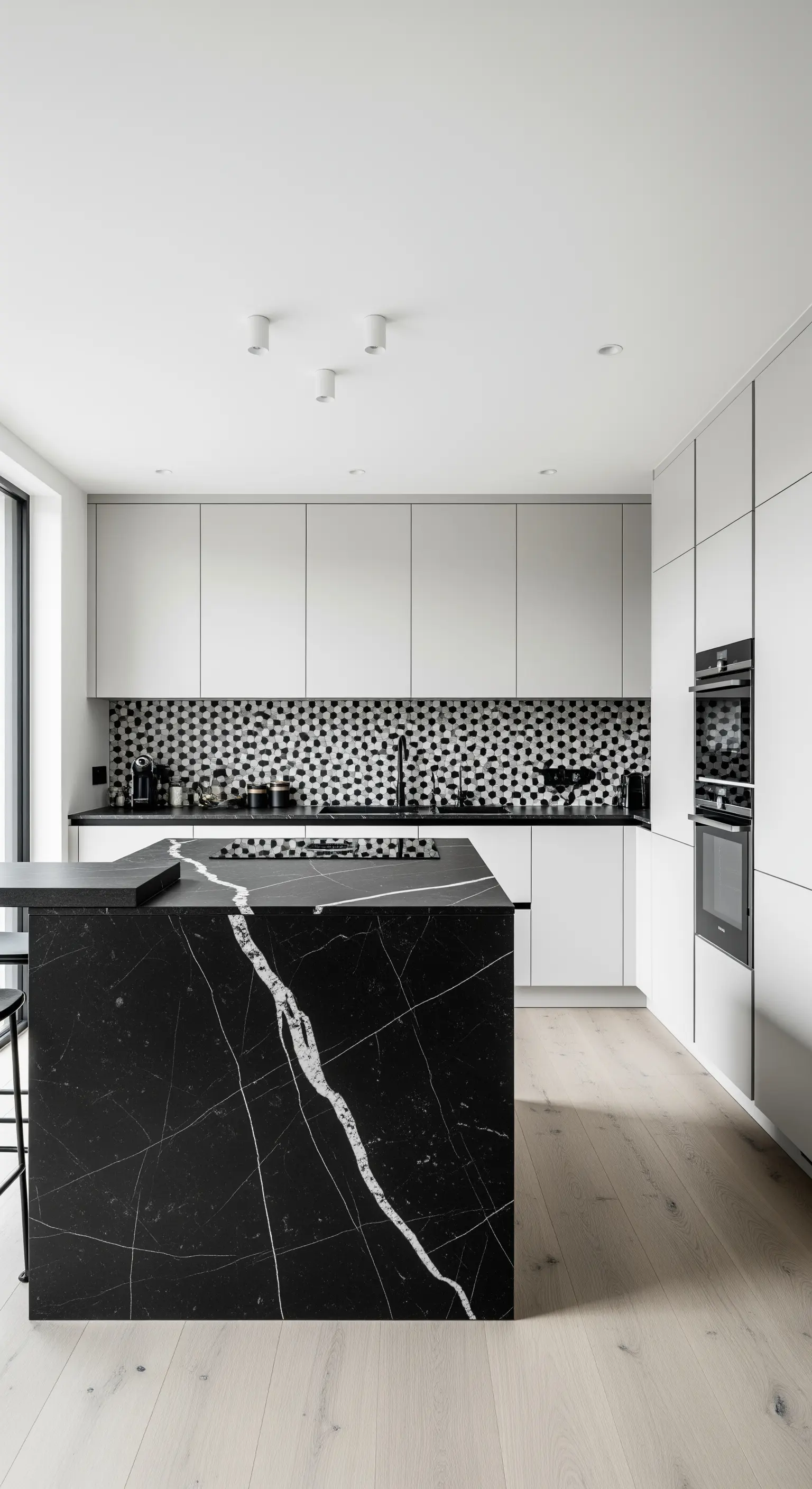 Minimalistische Küche mit schwarzer Marmorinsel und grafischem Fliesenspiegel.