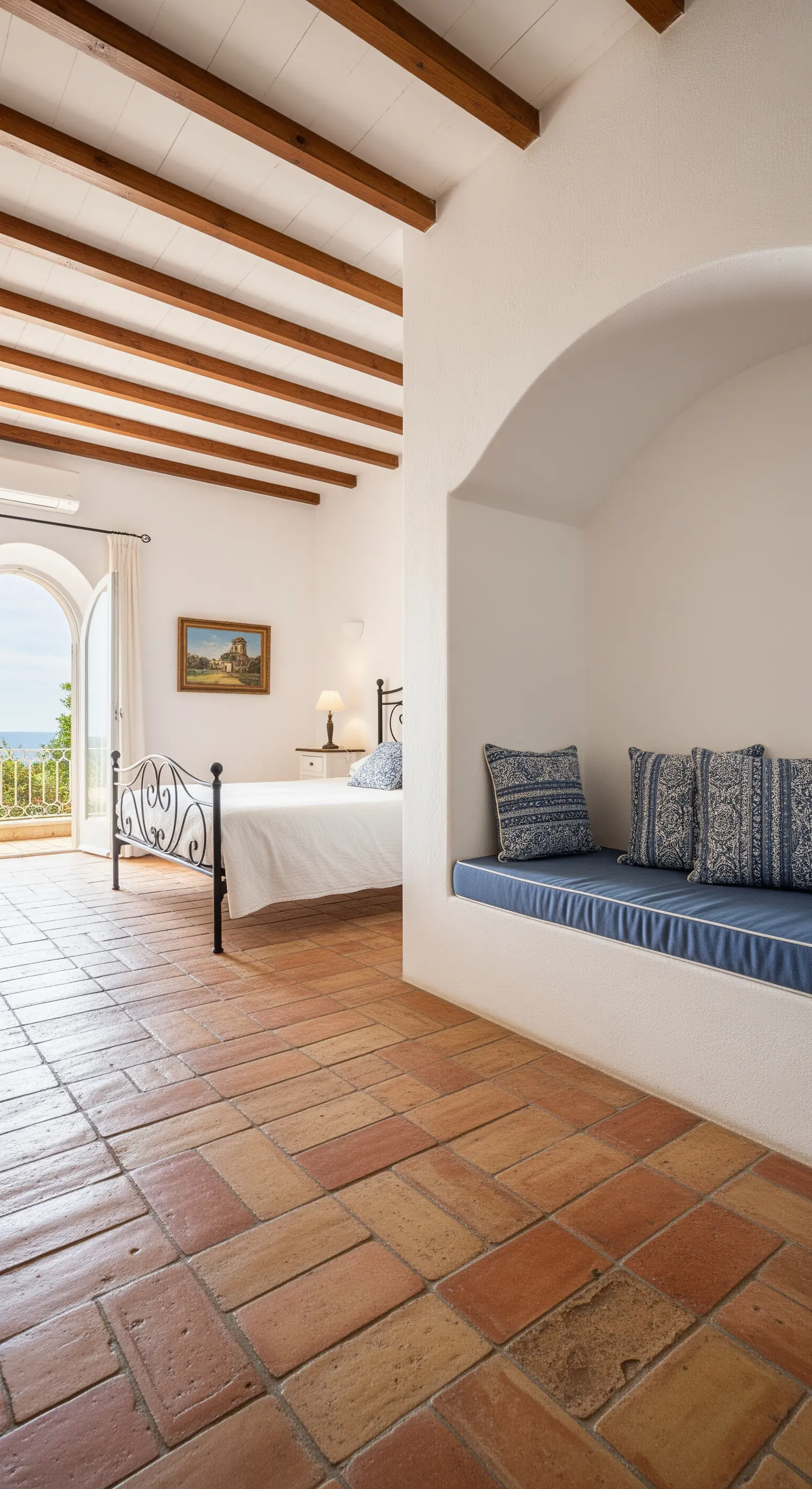 Mediterranes Schlafzimmer mit einer eingebauten Sitzecke in einer weiß verputzten Nische.