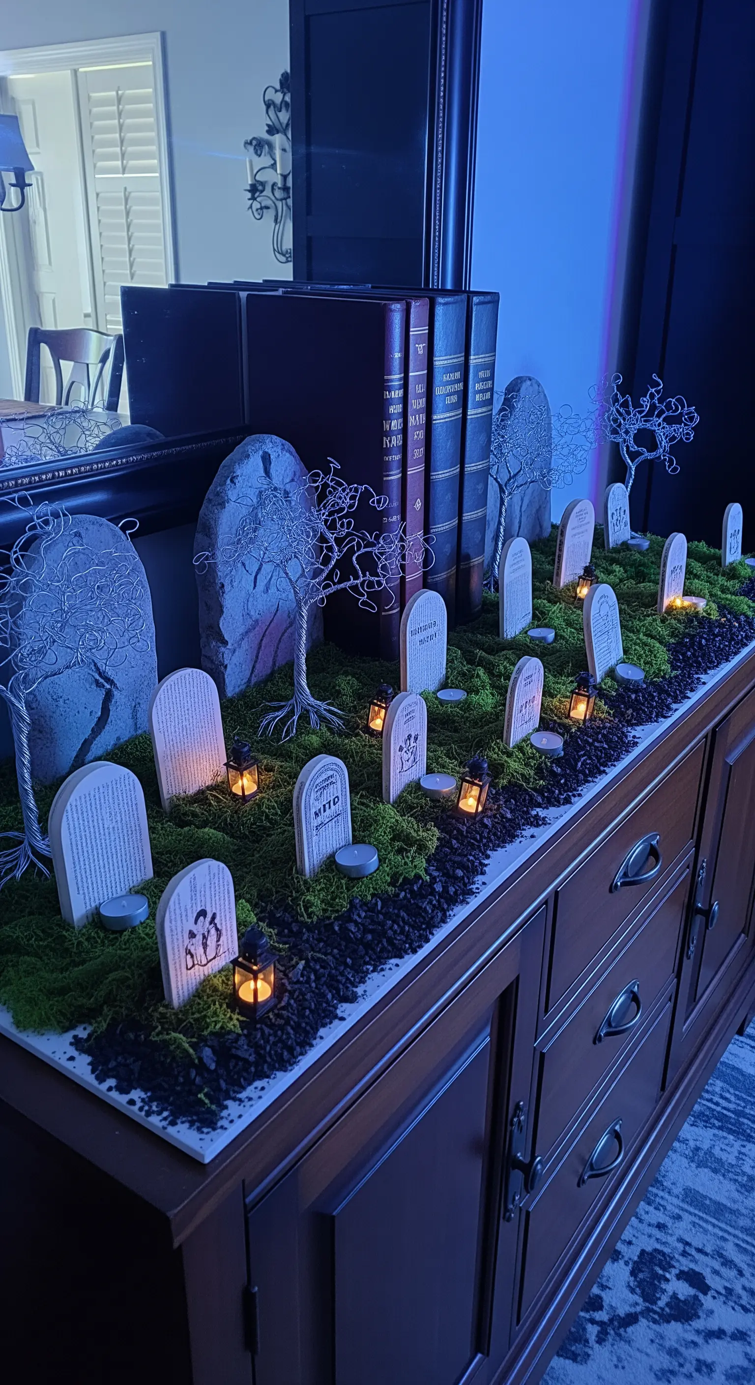 Miniatur-Friedhof, Sideboard, Grabsteine, Moos, Laternen, Bücher.