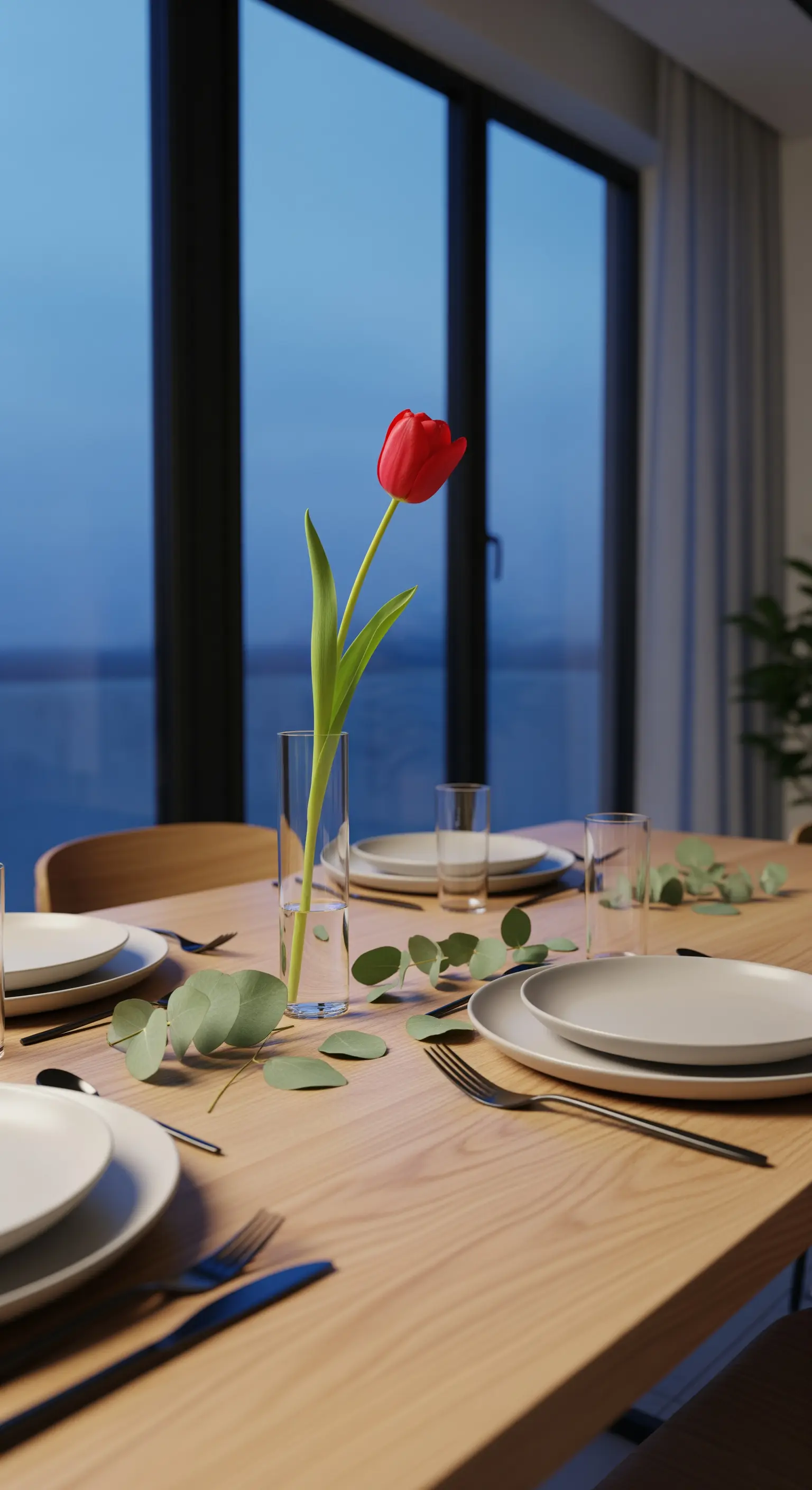 Schlichter Holztisch mit einer roten Tulpe und Eukalyptuszweigen, Abendstimmung