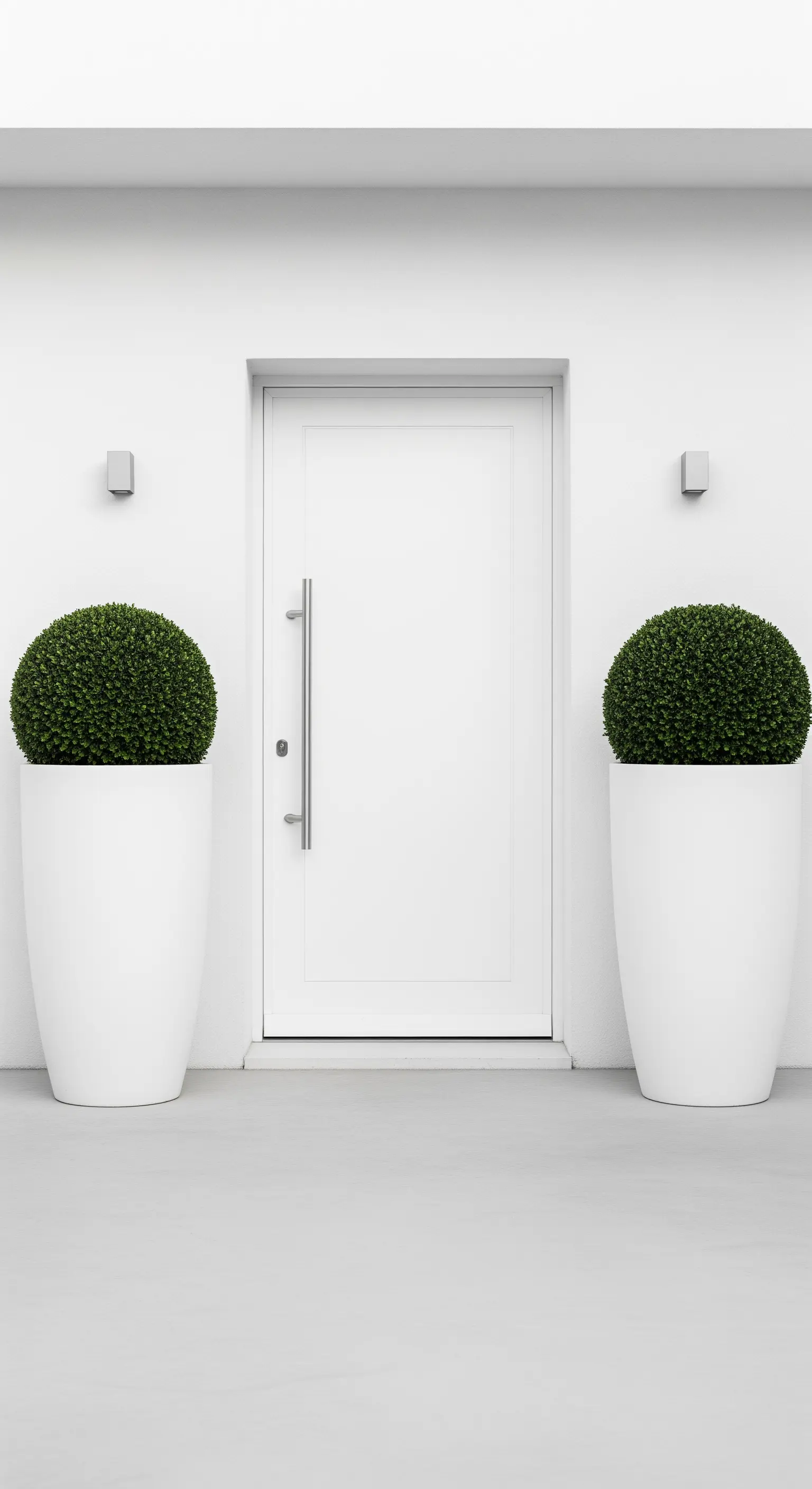 Weißer Eingang mit zwei kugelförmigen Topiary-Pflanzen