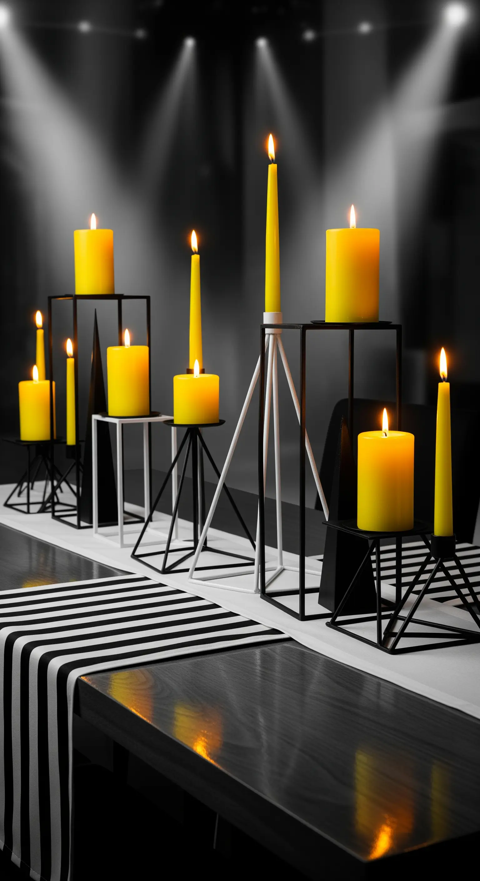 Minimalistischer Tisch mit schwarz-weißem Läufer, geometrischen Kerzenständern und gelben Kerzen.