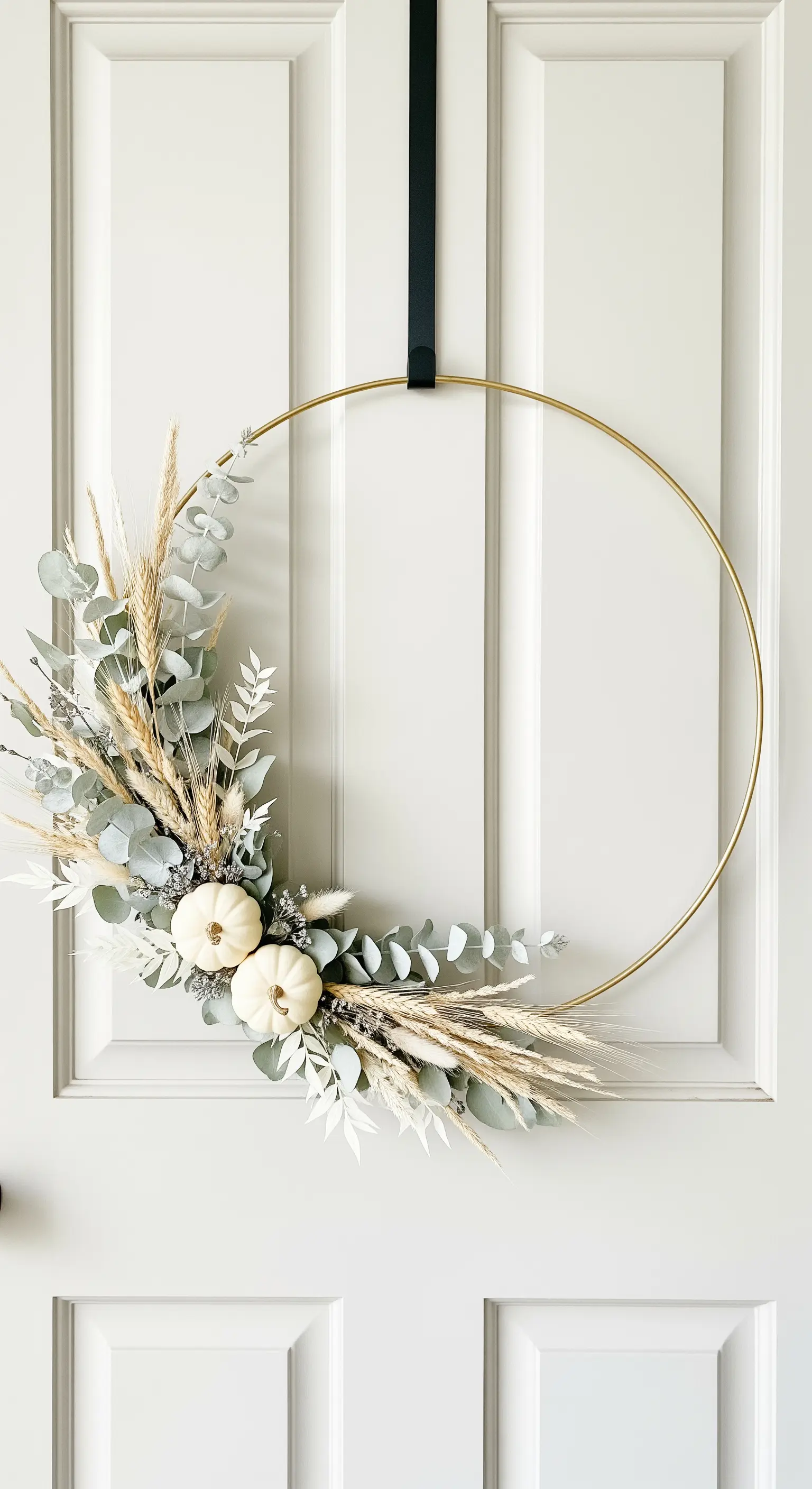 Moderner Goldring-Kranz mit Eukalyptus und weißen Mini-Kürbissen