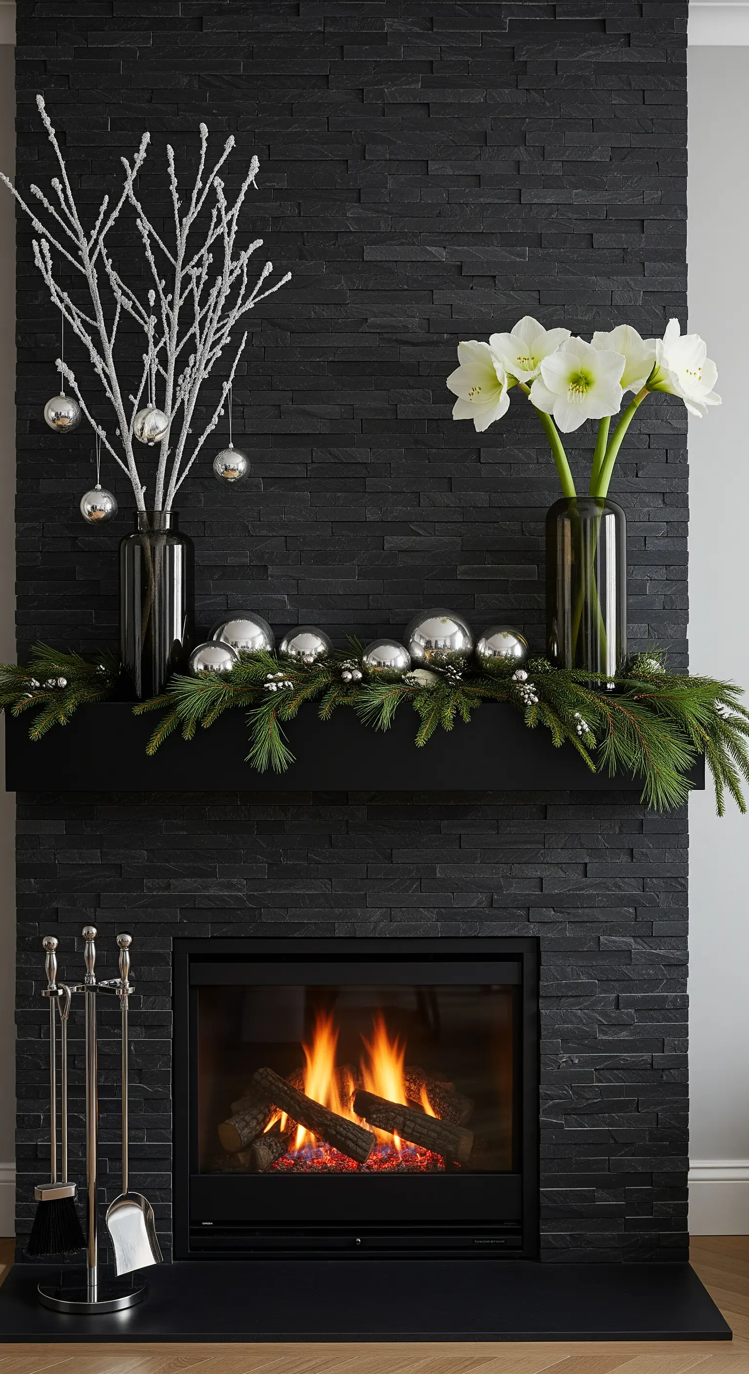 Schwarzer Stein-Kamin mit silbernen Kugeln, Amaryllis und schneebedeckten Zweigen