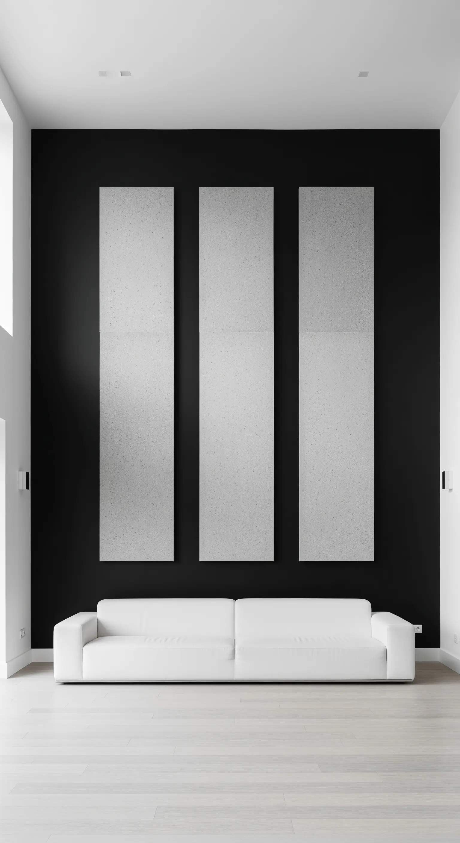 Drei große, hellgraue Akustikpaneele an einer schwarzen Wand hinter einem weißen Sofa.