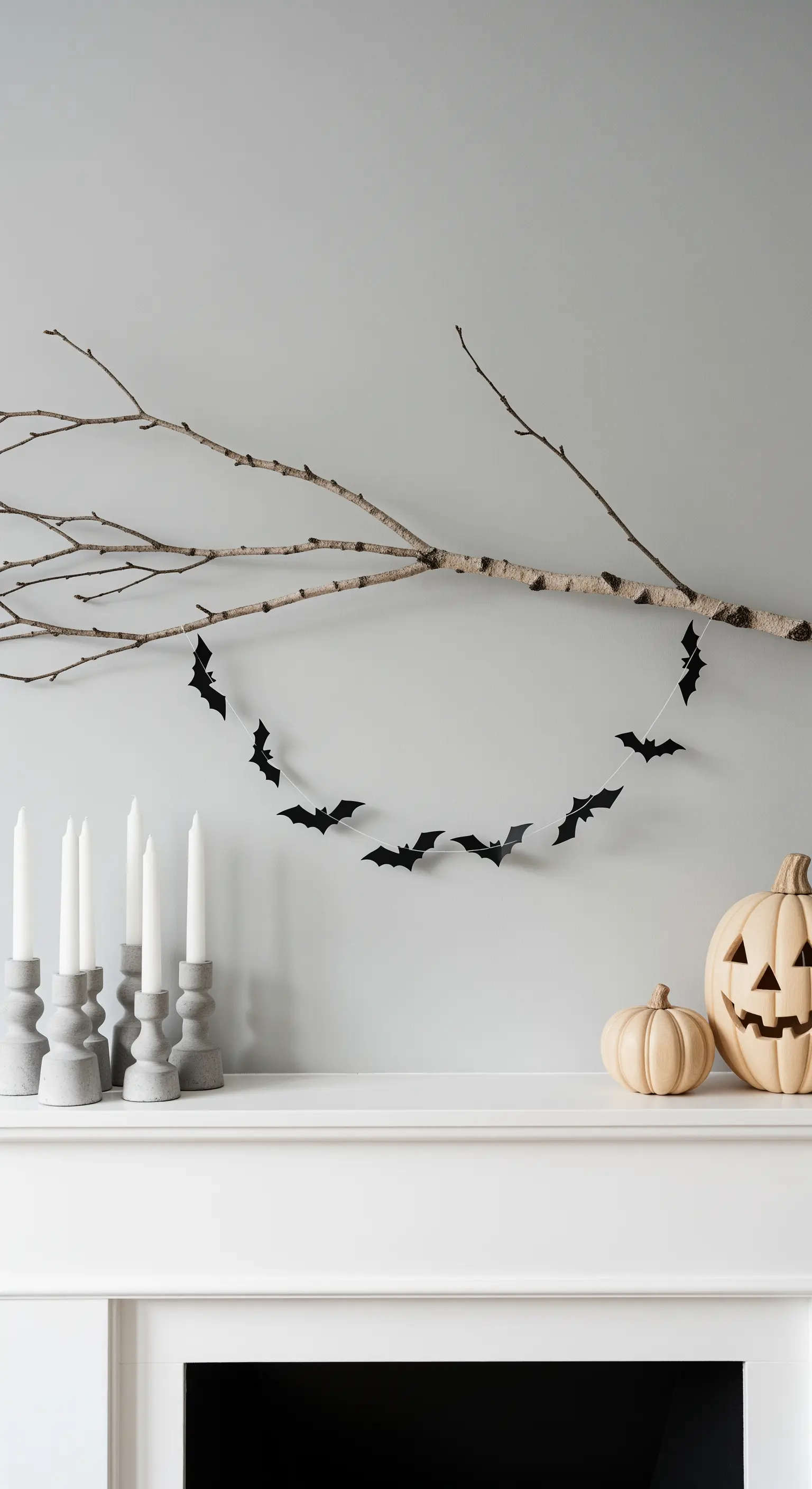 Kaminsims mit Ast, Fledermaus-Girlande und Beton-Kerzenhaltern