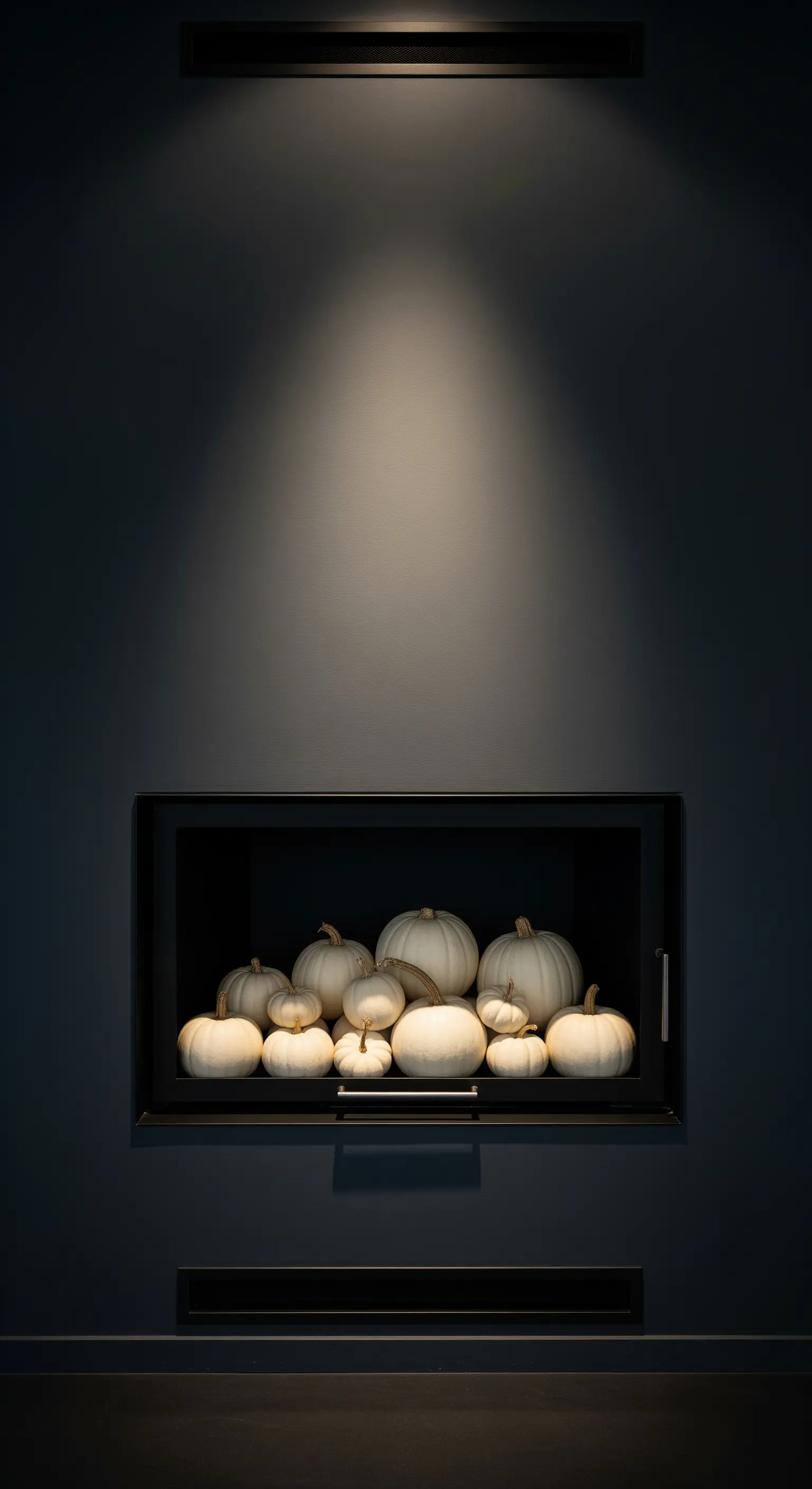 Dunkle Wandnische mit gezieltem Licht und einer Fülle weißer Kürbisse