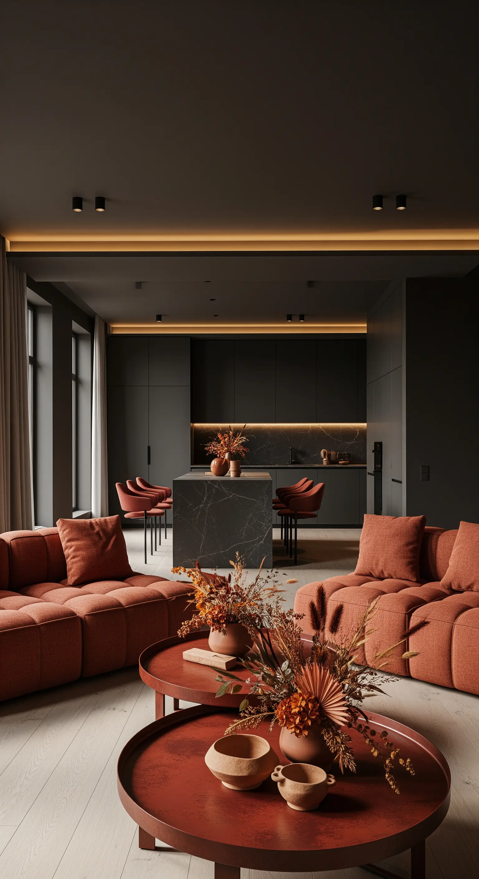 Offener Wohnbereich mit dunkler Küche, Terrakotta-Sofas und Herbstdeko
