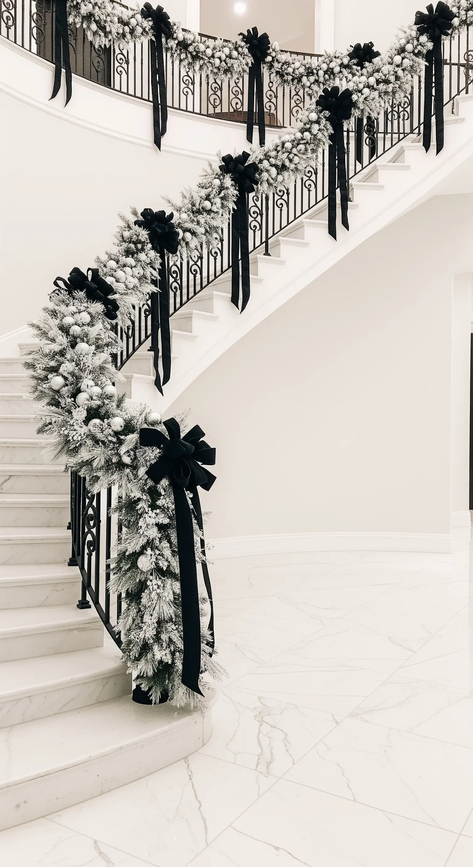 Prunkvolle Treppe mit beschneiter Girlande und eleganten schwarzen Schleifen.