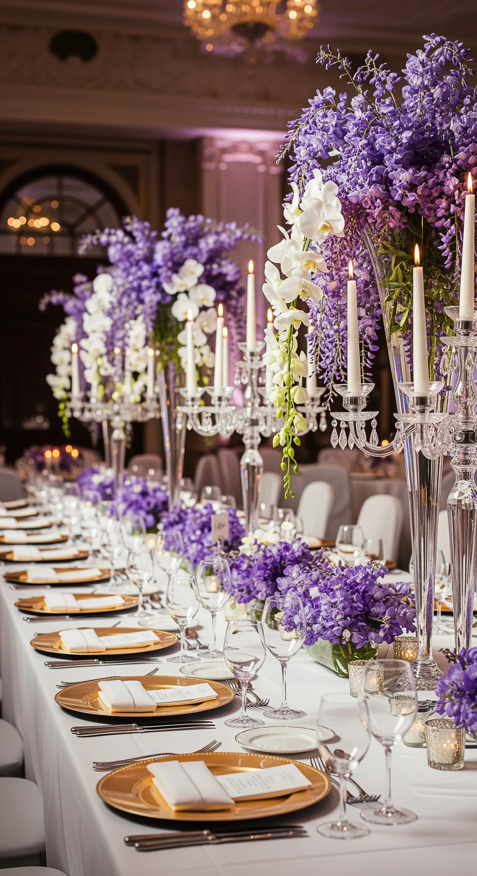 Üppige lila Wisteria und weiße Orchideen mit hohen Kristall-Kerzenleuchtern