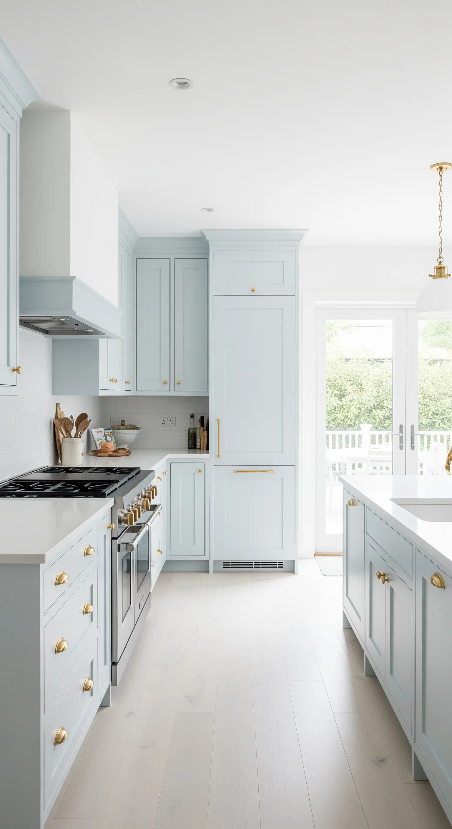 Pastellblaue Küche im Shaker-Stil mit goldenen Griffen und weißer Arbeitsplatte