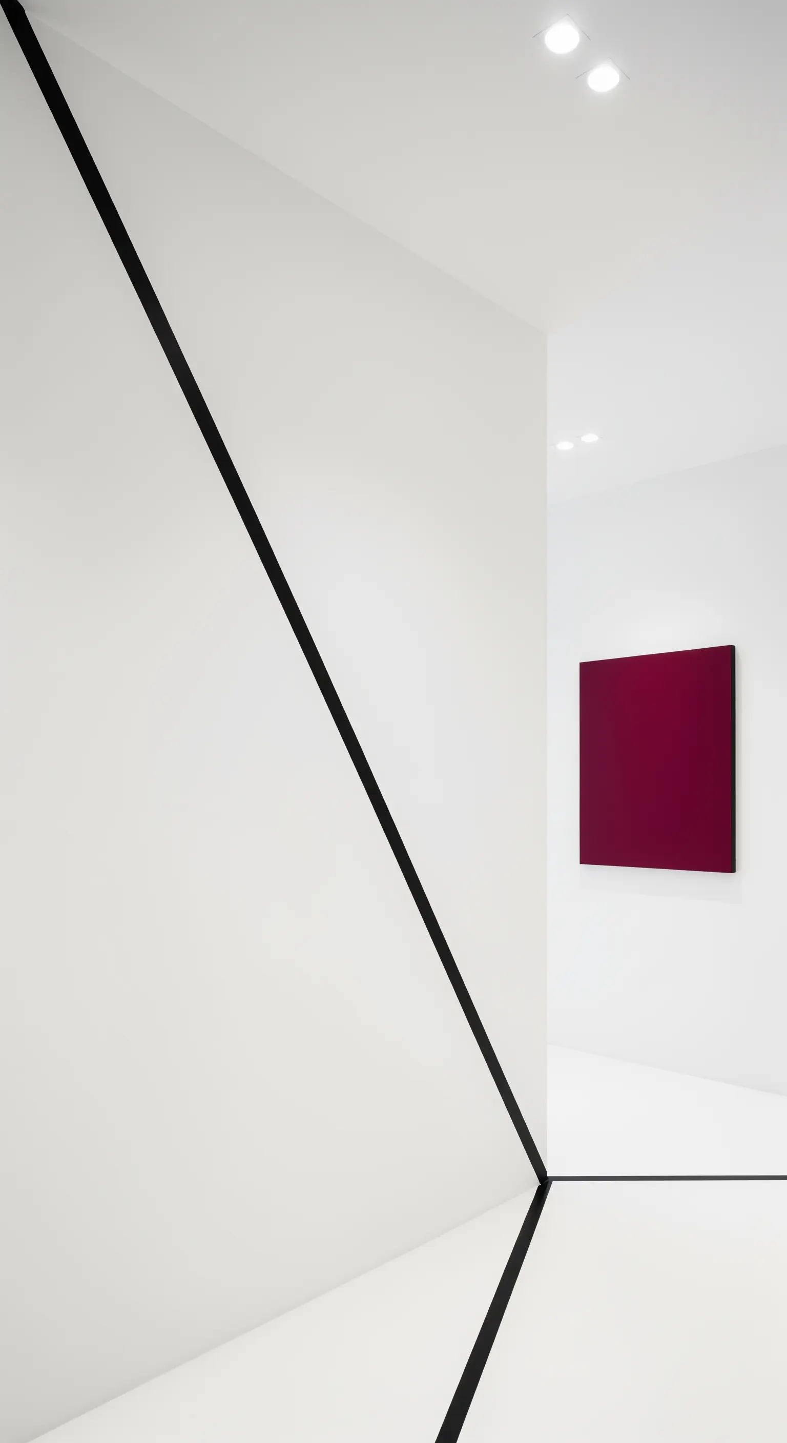 Schwarze Linien an Wand und Boden treffen auf ein weinrotes Quadrat in einer weißen Galerie.