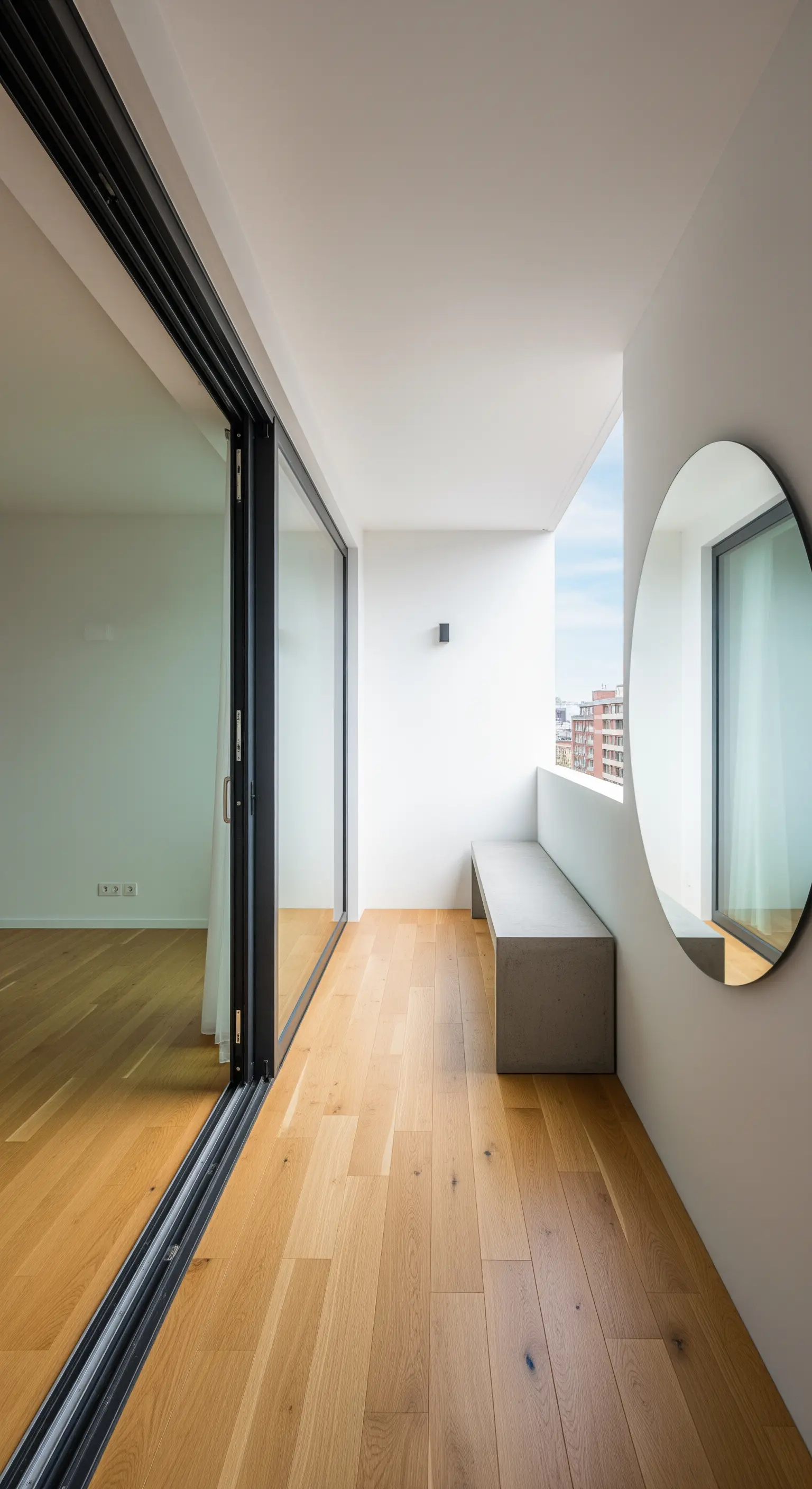 Großer runder Spiegel an Balkonwand über Betonbank