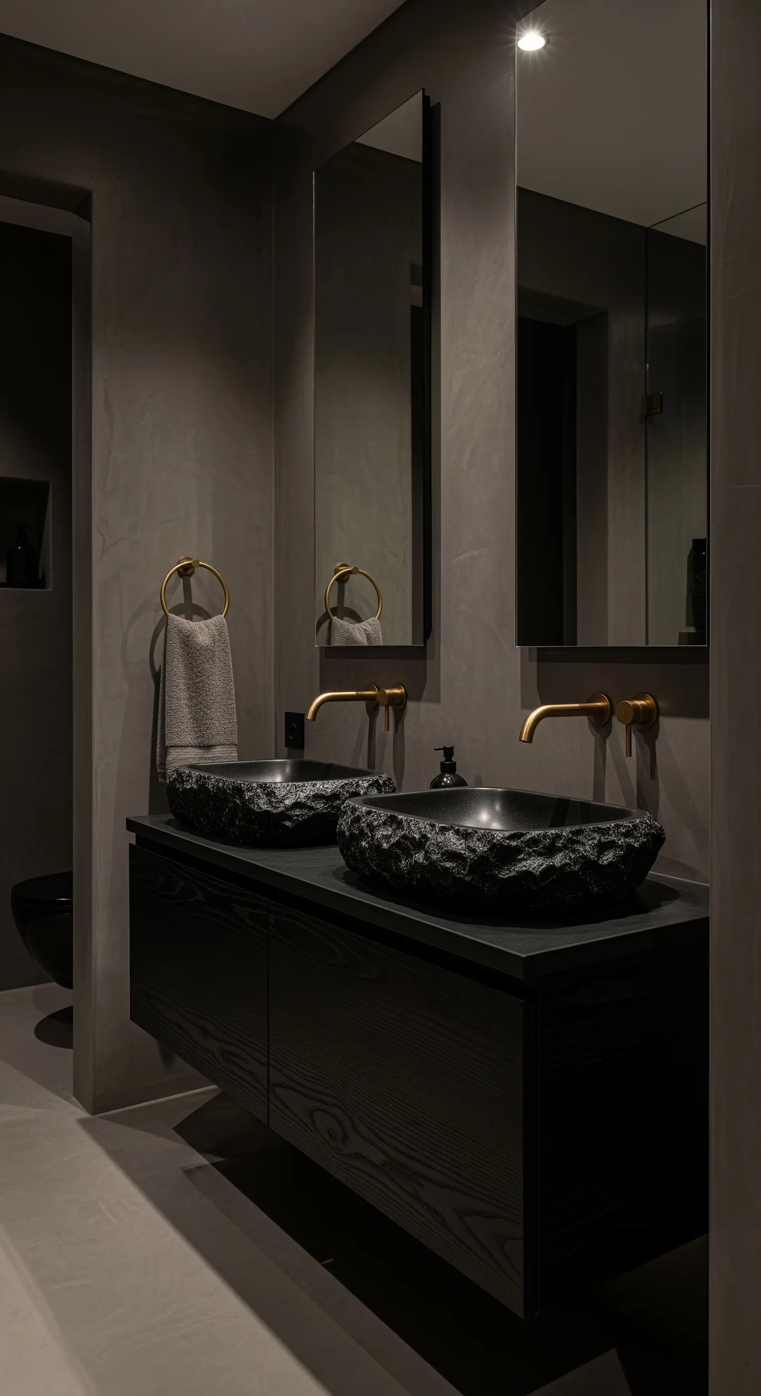 Dunkelgraues Bad, schwarze Steinwaschbecken, goldene Armaturen, Holzunterschrank