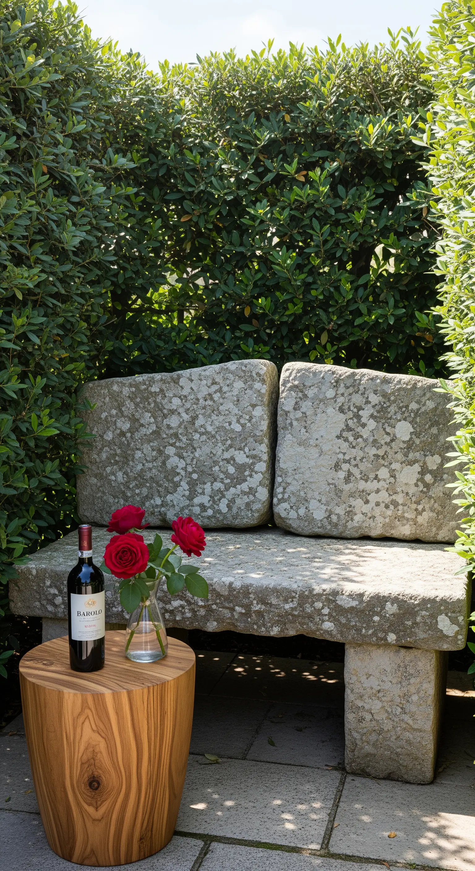 Steinbank mit Olivenholz-Beistelltisch, Wein und roten Rosen in einer grünen Nische