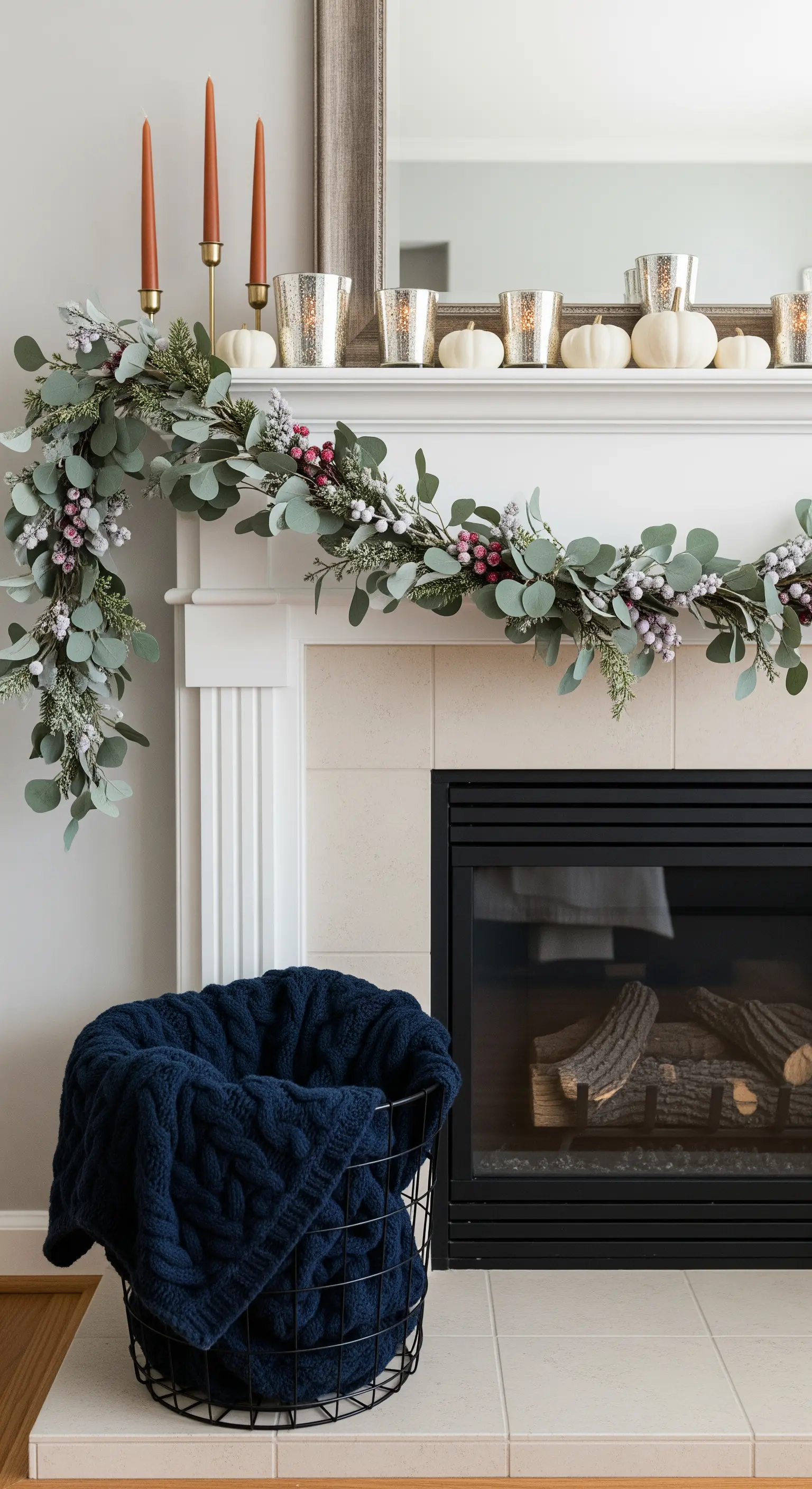 Kamingirlande aus Eukalyptus und Beeren mit weißen Kürbissen und Windlichtern.