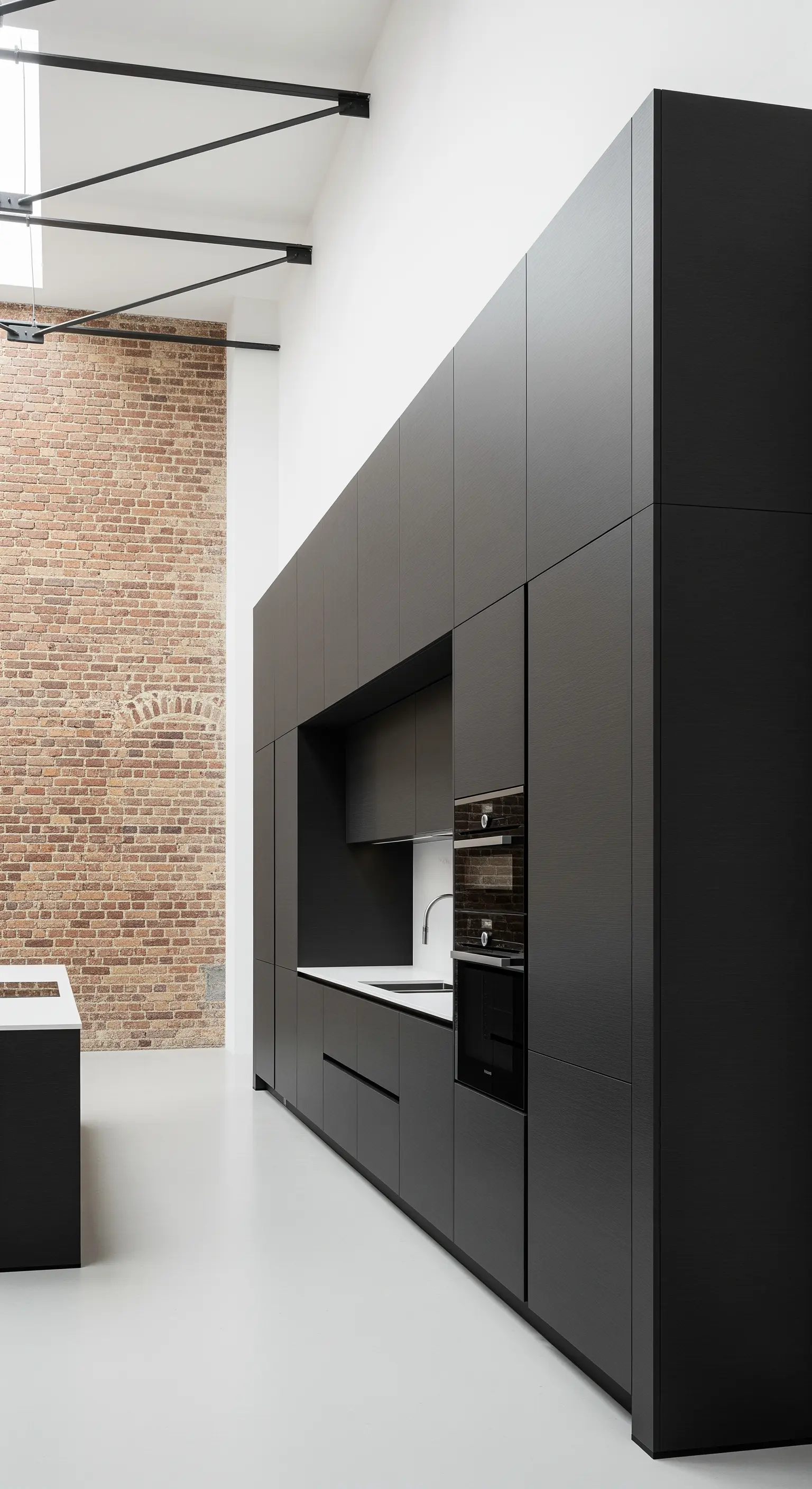 Monolithischer schwarzer Küchenblock vor einer freigelegten Backsteinwand