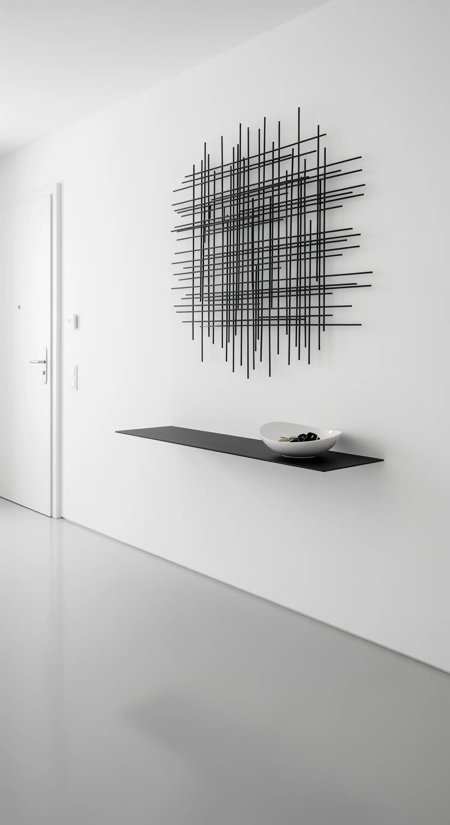 Minimalistischer Eingangsbereich mit schwarzem Schwebe-Regal und Wandskulptur.