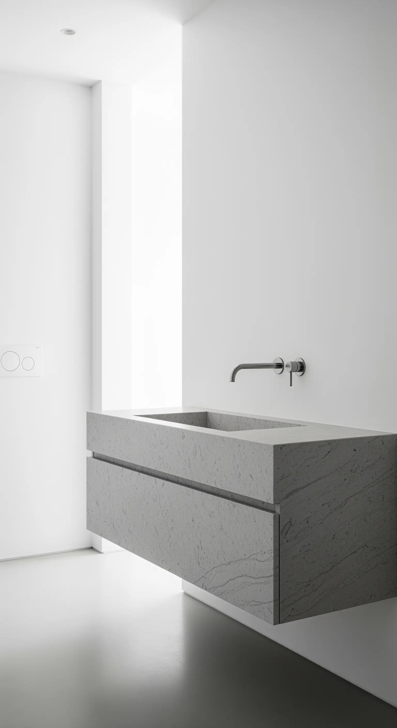 Schwebender, minimalistischer Waschtisch aus grauem Stein in einem weißen Raum.