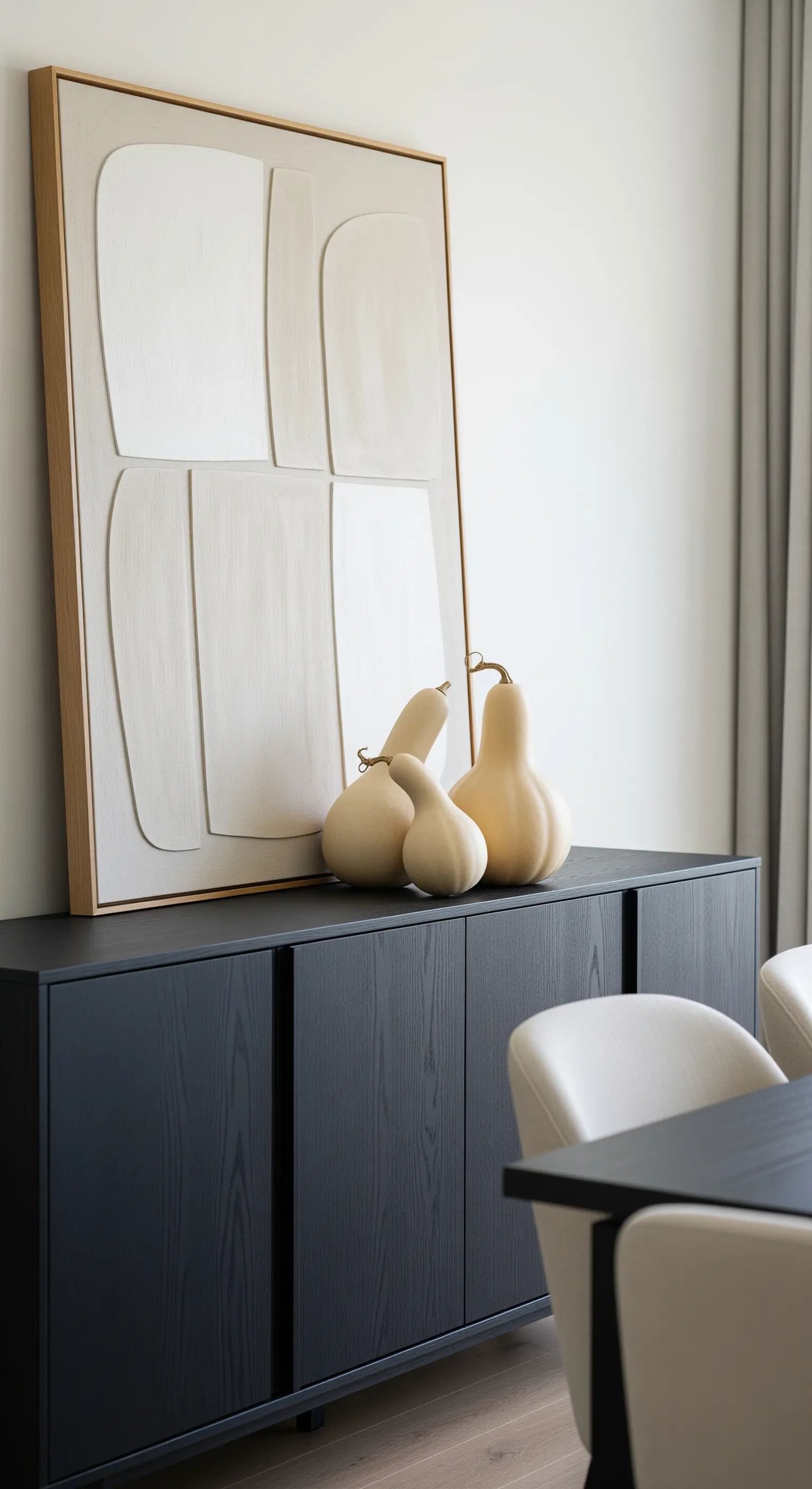 Gruppe von hellen, flaschenförmigen Kürbissen auf einem schwarzen Sideboard.