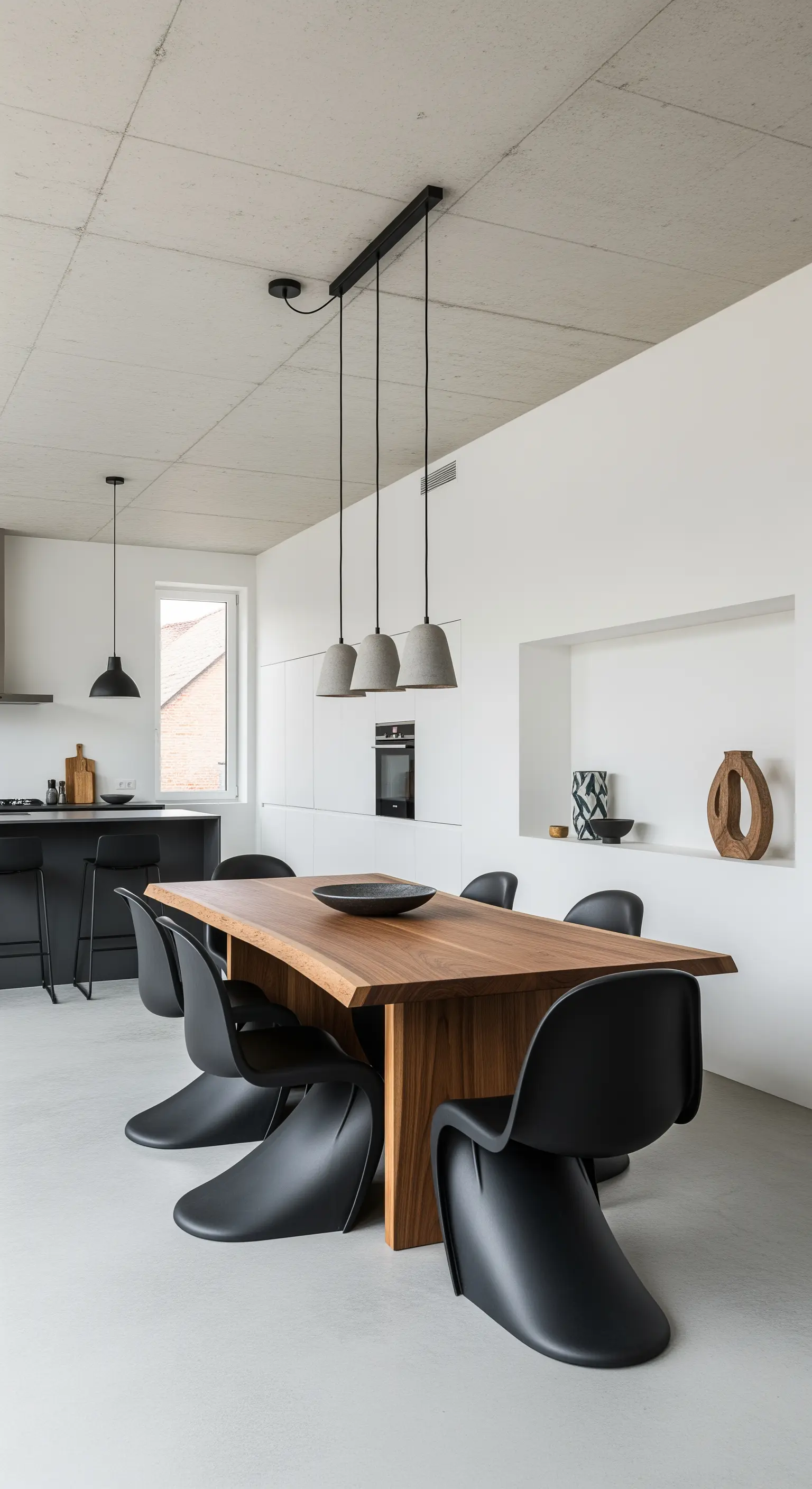 Essbereich mit Holztisch und Beton-Pendelleuchten.