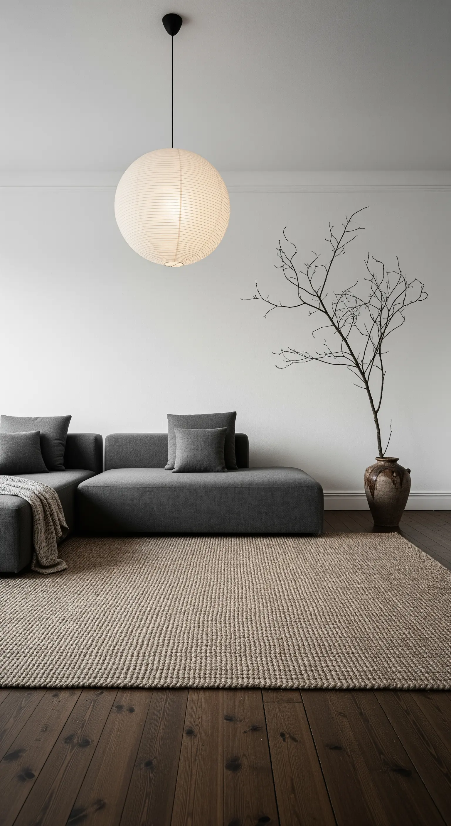 Ein kahler Ast in einer Bodenvase als skulpturales Statement für minimalistische Wohnräume.